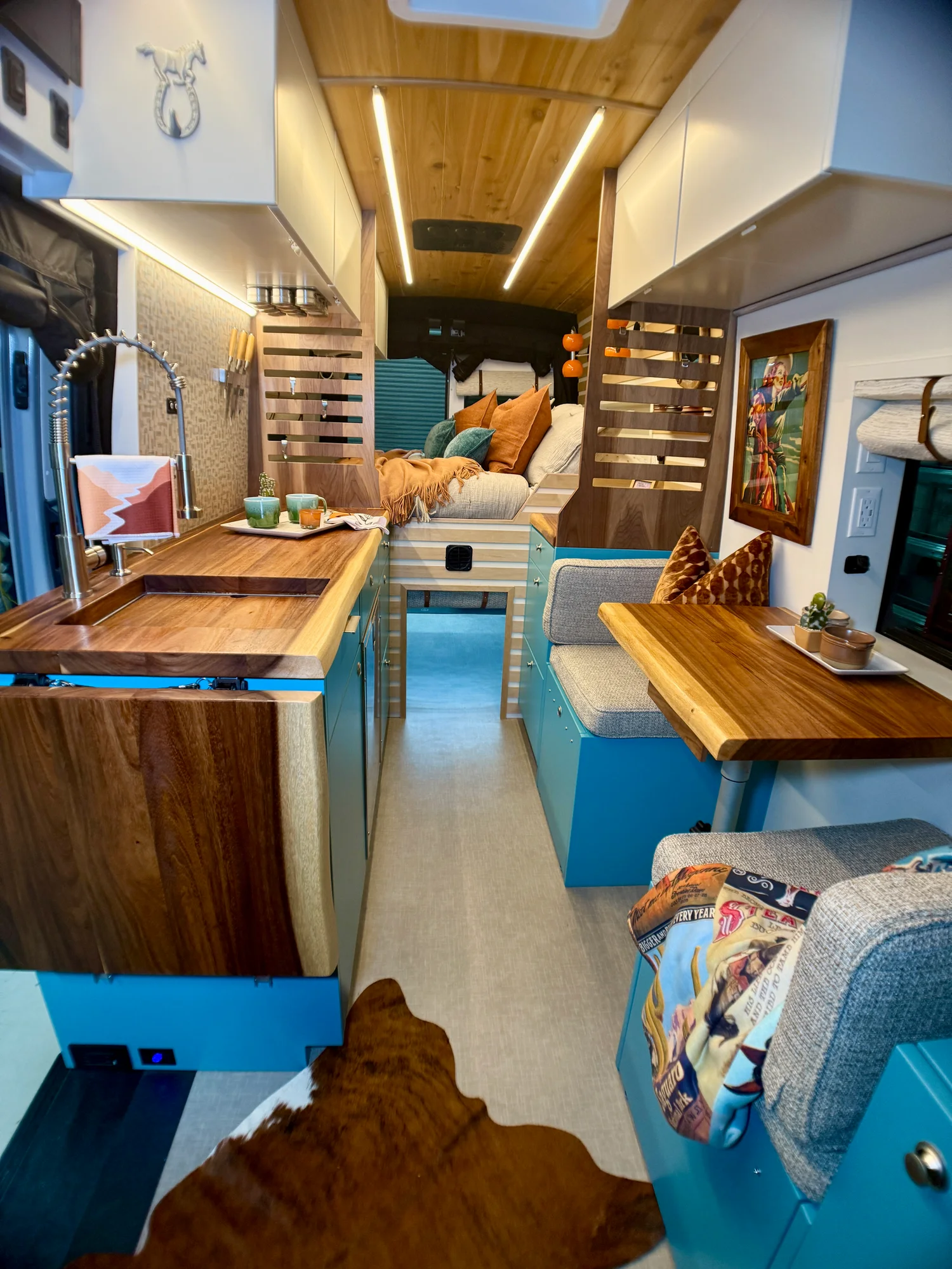 The Drifter 101 custom Ford Transit campervan built for Zach and Stephanie by Drifter Vans, with turquoise cabinetry, a custom wine rack, and Texas-inspired mid-century details