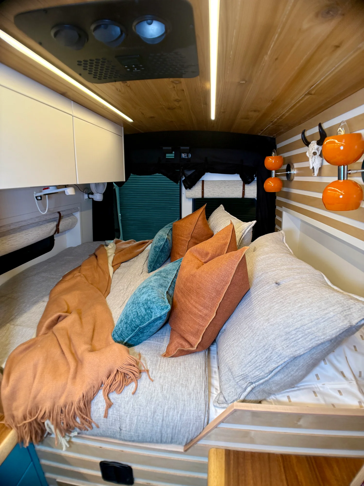 The Drifter 101 custom Ford Transit campervan built for Zach and Stephanie by Drifter Vans, with turquoise cabinetry, a custom wine rack, and Texas-inspired mid-century details