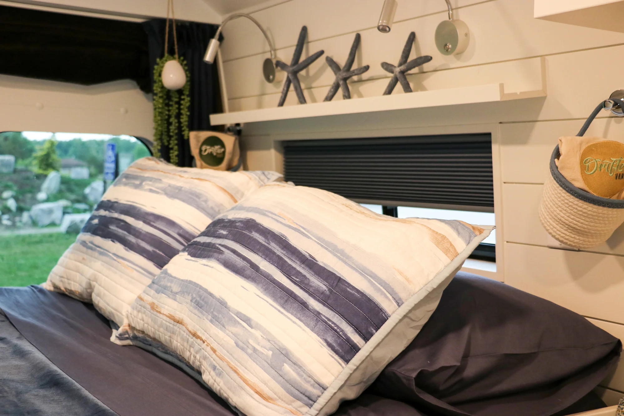 The Drifter 101 custom Ram ProMaster campervan built for Karen by Drifter Vans, Nomadik layout with coastal blue cabinetry, subway tile backsplash, and a white marble wet bath