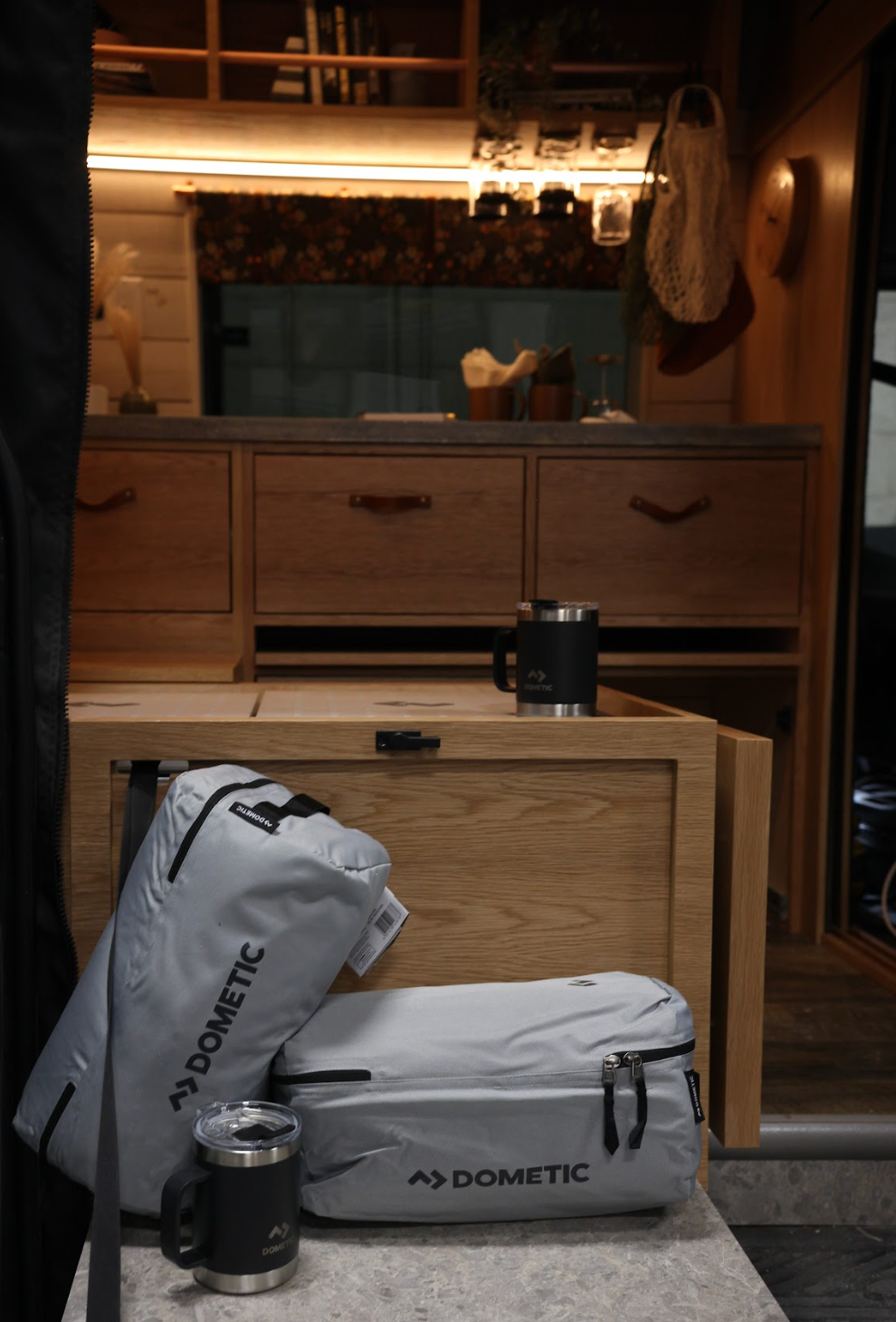 The Drifter 101 custom Ford Transit campervan built for Gardner by Drifter Vans, with warm wood paneling, earthy tones, soft seating, and modular storage