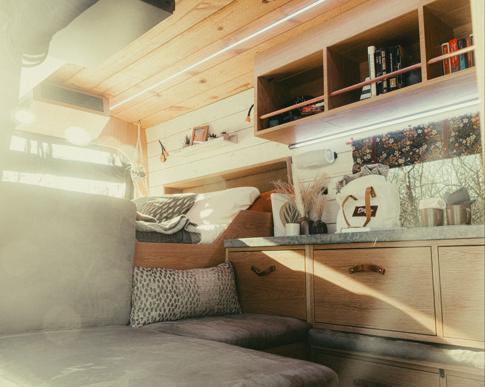 The Drifter 101 custom Ford Transit campervan built for Gardner by Drifter Vans, with warm wood paneling, earthy tones, soft seating, and modular storage