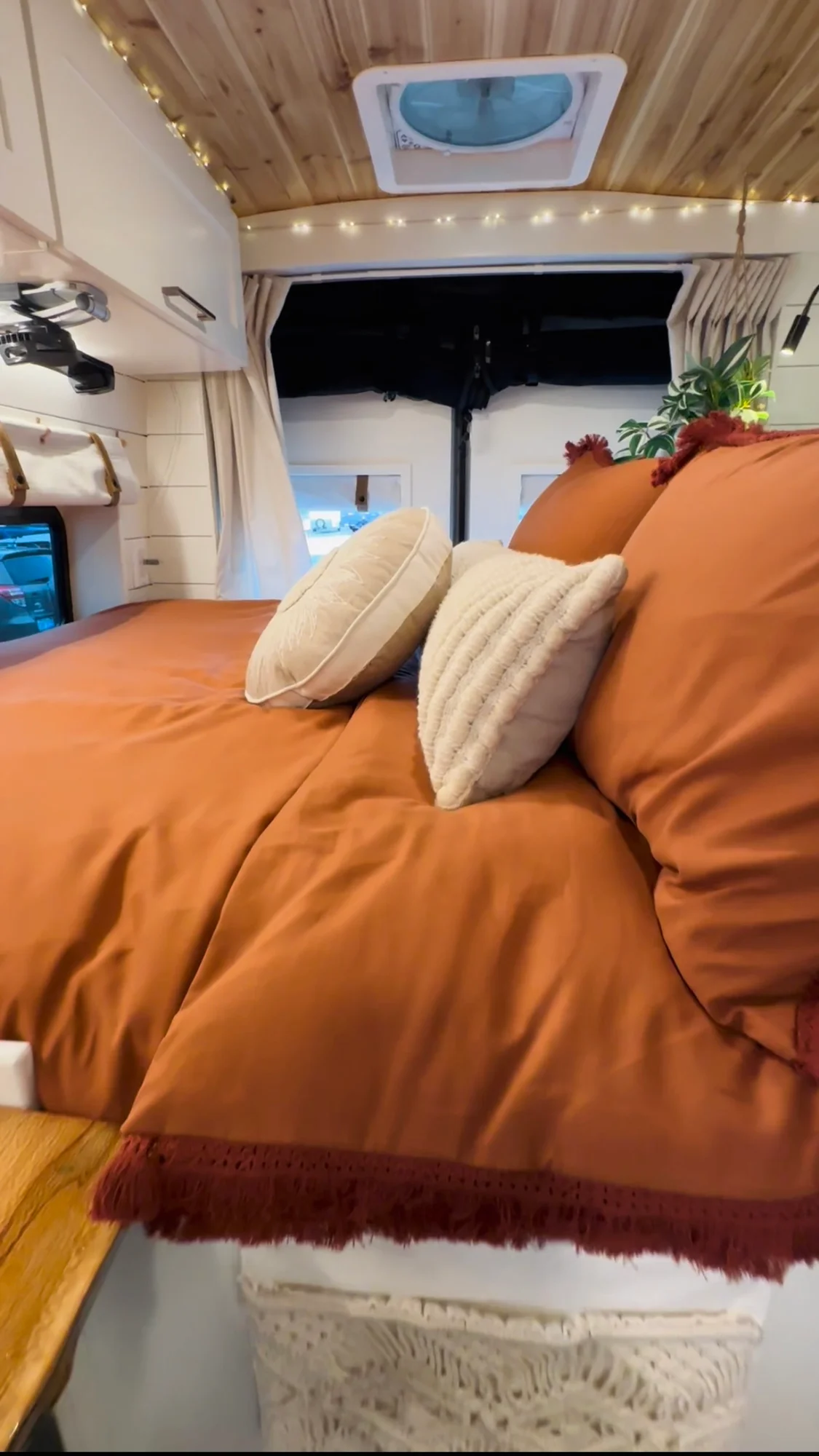 The Drifter 101 custom Ford Transit campervan built for Meredith by Drifter Vans, Wanderer layout with an earthy boho interior, rust linen bedding, and a natural wood countertop