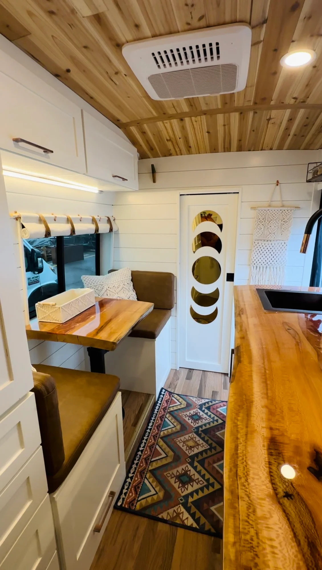The Drifter 101 custom Ford Transit campervan built for Meredith by Drifter Vans, Wanderer layout with an earthy boho interior, rust linen bedding, and a natural wood countertop