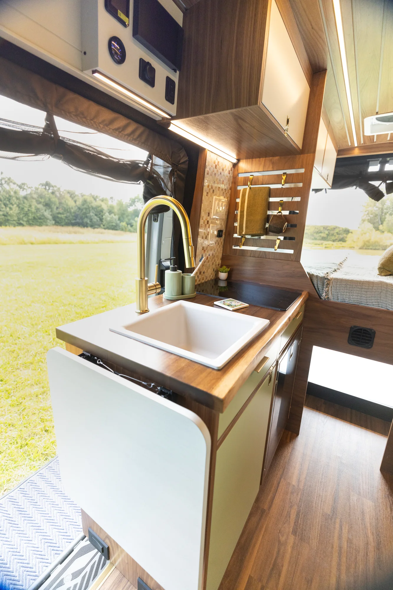 The Drifter 101 custom Ford Transit campervan built for Susan by Drifter Vans, Wanderer layout with modern nautical styling, mother of pearl tile, walnut cabinetry, and blue and white accents