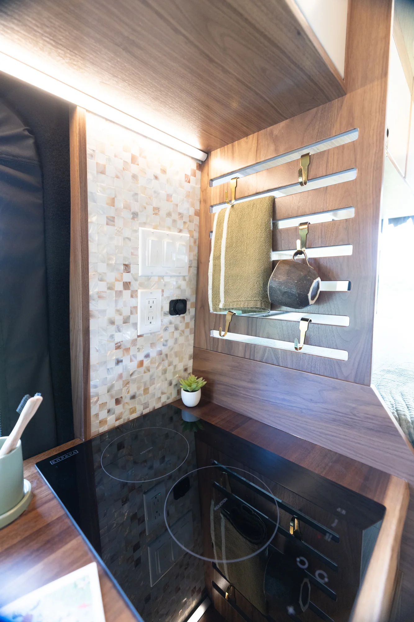 The Drifter 101 custom Ford Transit campervan built for Susan by Drifter Vans, Wanderer layout with modern nautical styling, mother of pearl tile, walnut cabinetry, and blue and white accents