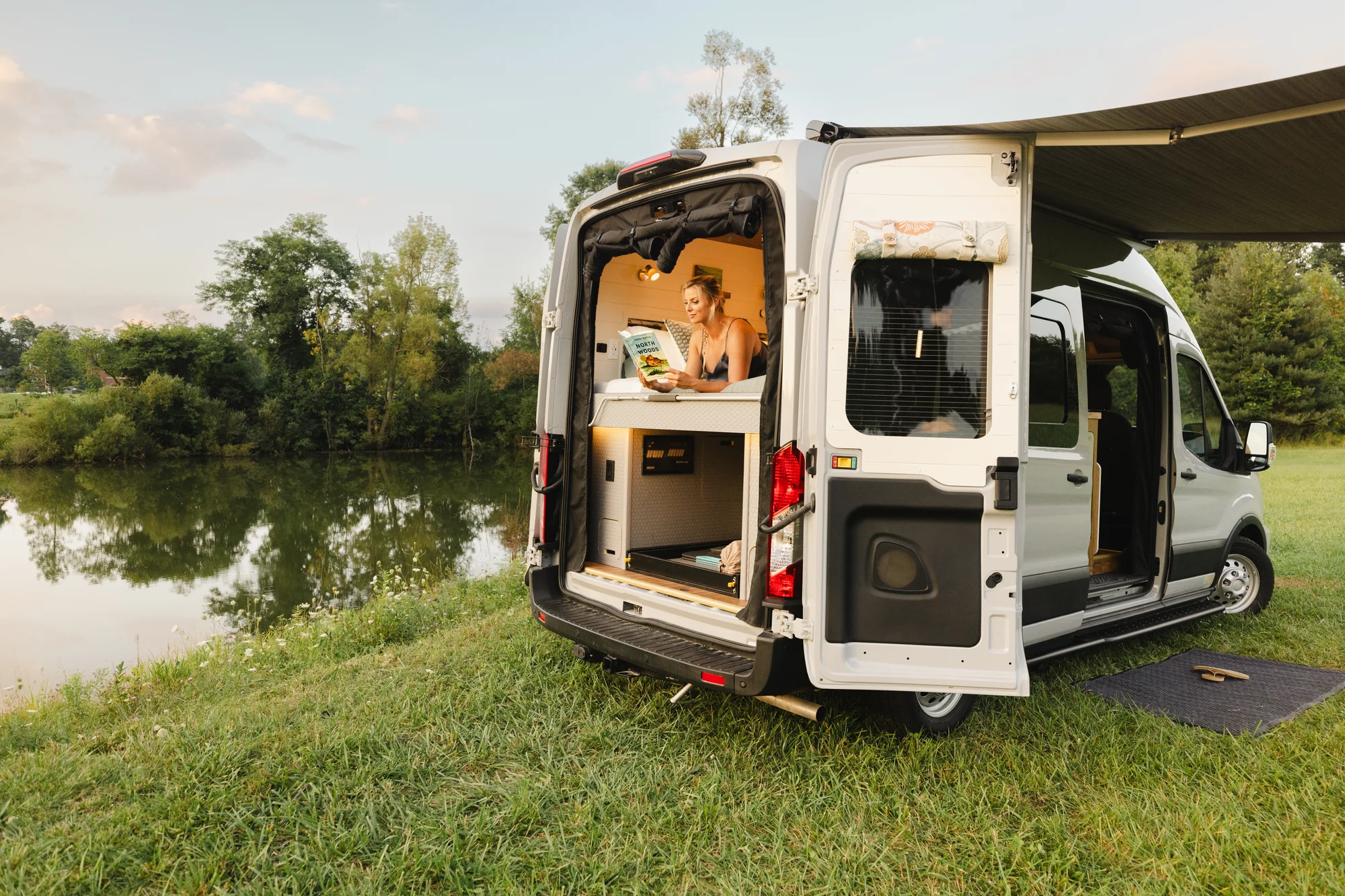 The Drifter 101 custom Ford Transit campervan built for Susan by Drifter Vans, Wanderer layout with modern nautical styling, mother of pearl tile, walnut cabinetry, and blue and white accents