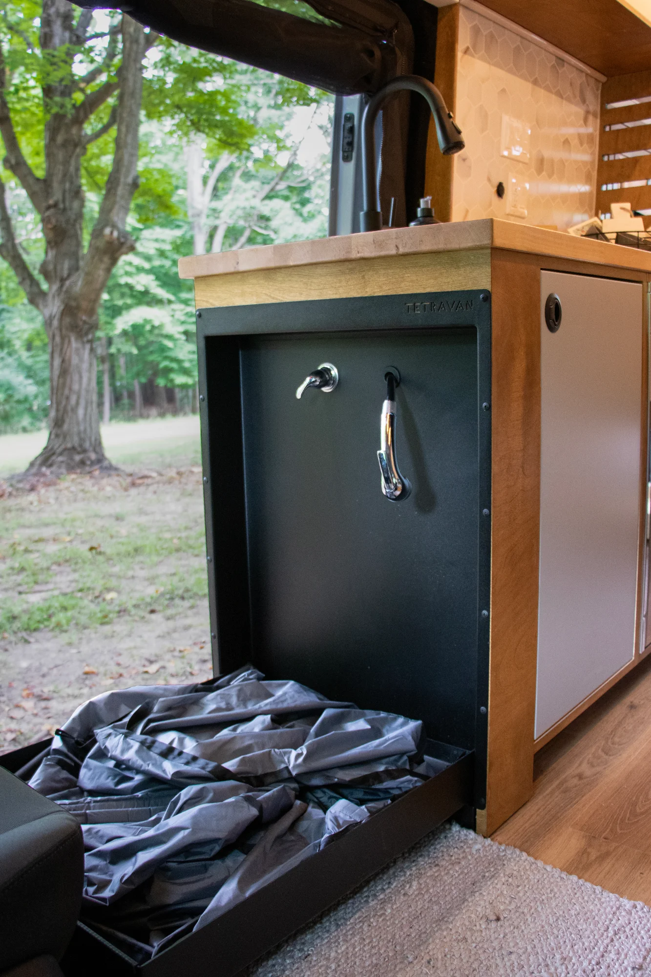 The Drifter 101 custom Ford Transit campervan built for Terry and Michelle by Drifter Vans, Drifter layout with a modern farmhouse interior, gold hardware accents, Tetra shower, and Lagun table