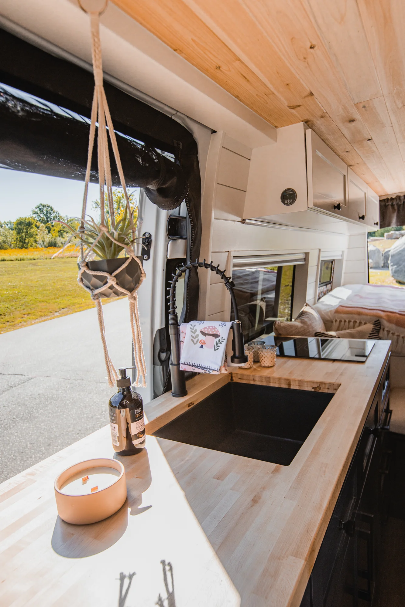 The Drifter 101 custom Mercedes-Benz Sprinter campervan built for Katie by Drifter Vans, with a pink boho interior, butcher block countertop, natural textures, and a full shower