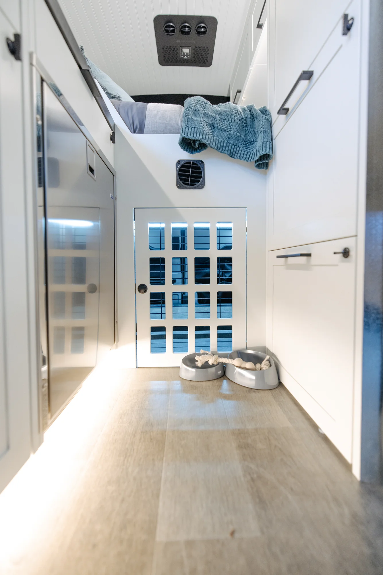 The Drifter 101 custom Ford Transit campervan built for Lisa by Drifter Vans, Wanderer layout with a beachy coastal interior, light blue and white finishes, dog-friendly built-ins, and a swivel chair