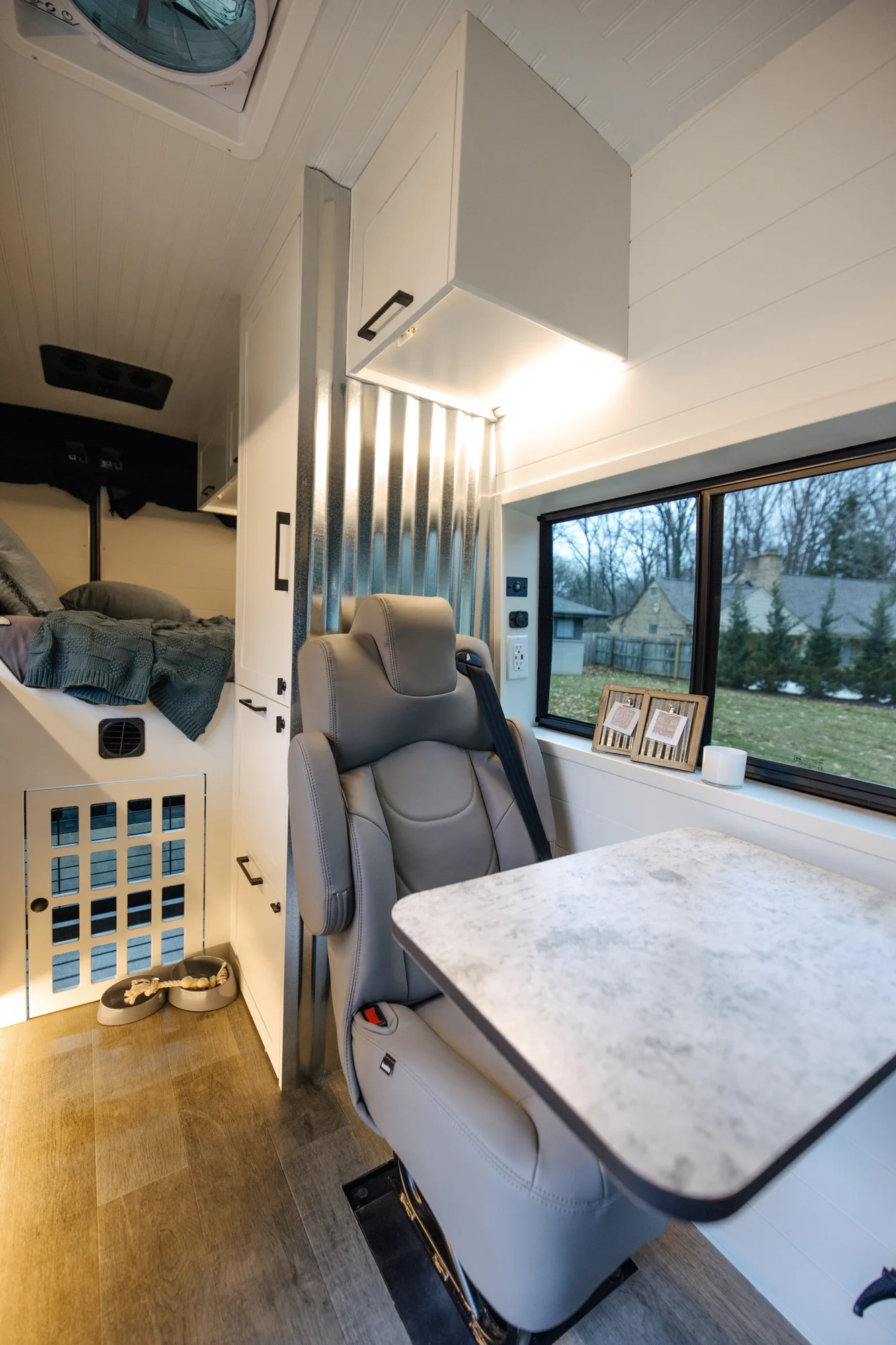 The Drifter 101 custom Ford Transit campervan built for Lisa by Drifter Vans, Wanderer layout with a beachy coastal interior, light blue and white finishes, dog-friendly built-ins, and a swivel chair