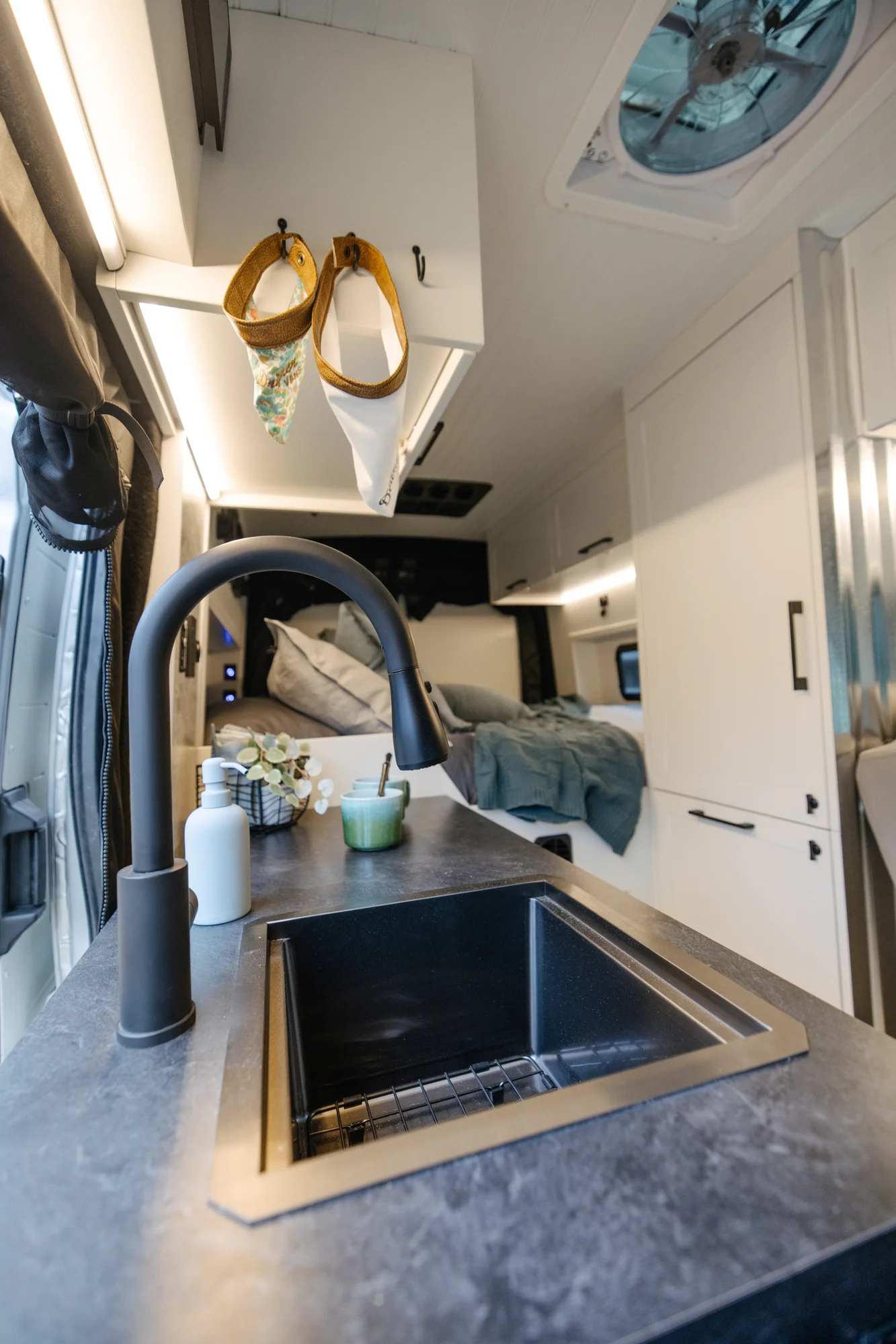 The Drifter 101 custom Ford Transit campervan built for Lisa by Drifter Vans, Wanderer layout with a beachy coastal interior, light blue and white finishes, dog-friendly built-ins, and a swivel chair