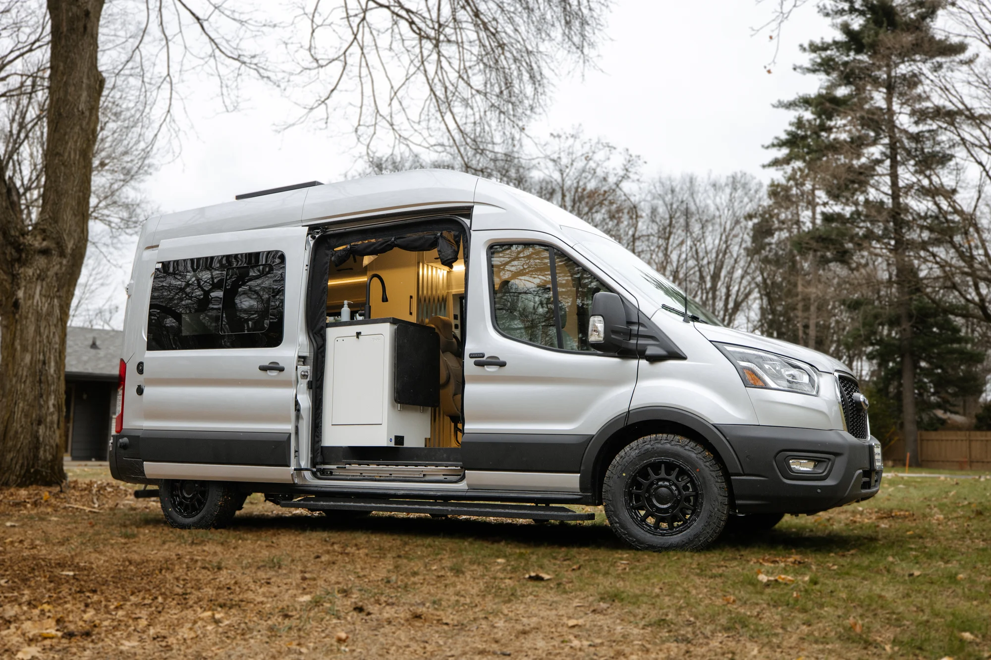The Drifter 101 custom Ford Transit campervan built for Lisa by Drifter Vans, Wanderer layout with a beachy coastal interior, light blue and white finishes, dog-friendly built-ins, and a swivel chair