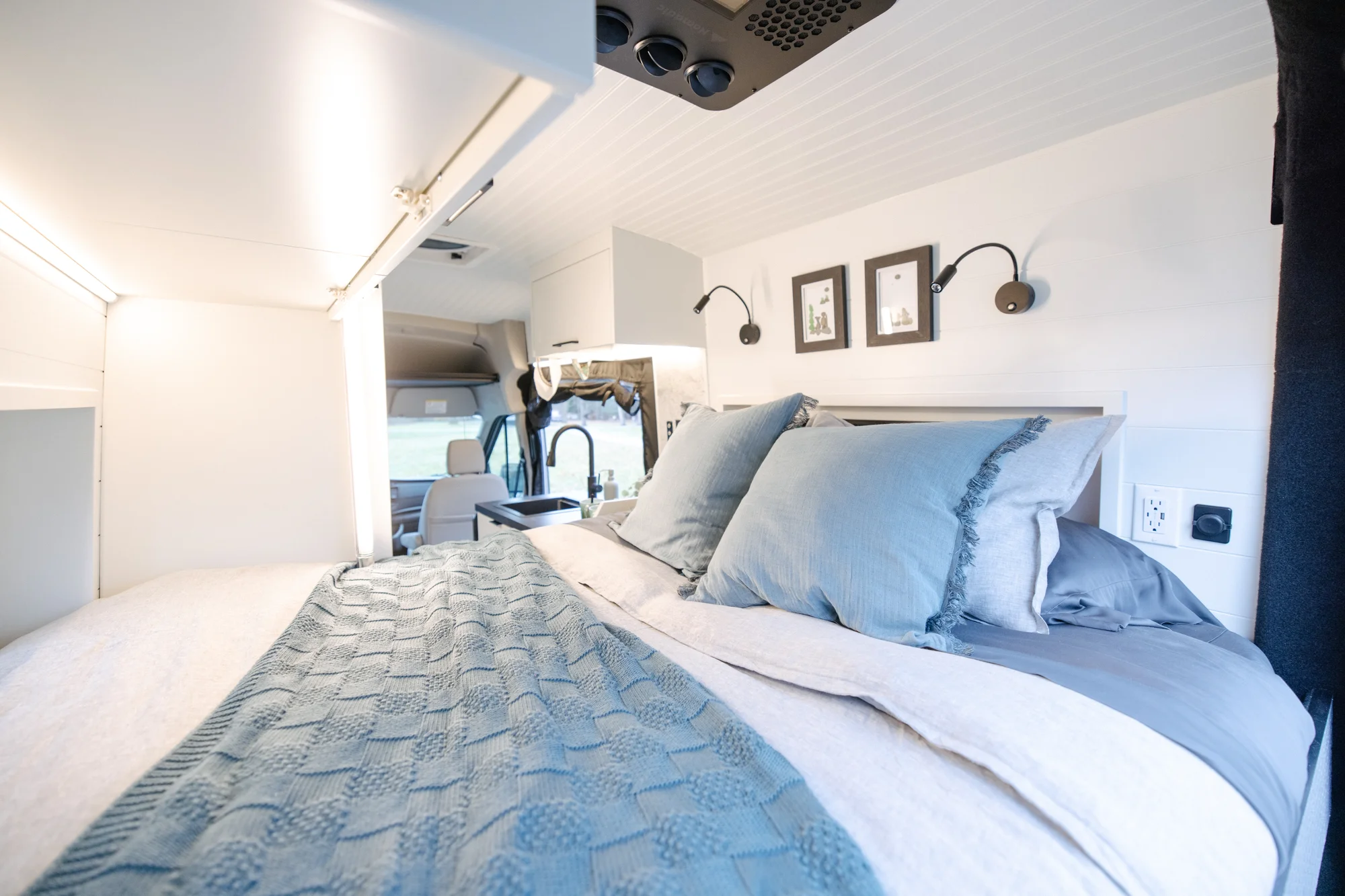 The Drifter 101 custom Ford Transit campervan built for Lisa by Drifter Vans, Wanderer layout with a beachy coastal interior, light blue and white finishes, dog-friendly built-ins, and a swivel chair