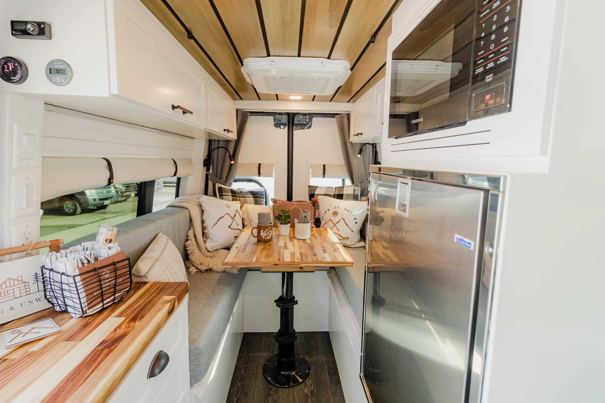The Drifter 101 custom Mercedes-Benz Sprinter campervan built for Dave by Drifter Vans, with a wood plank ceiling, butcher block countertop, black faucet, and stainless appliances