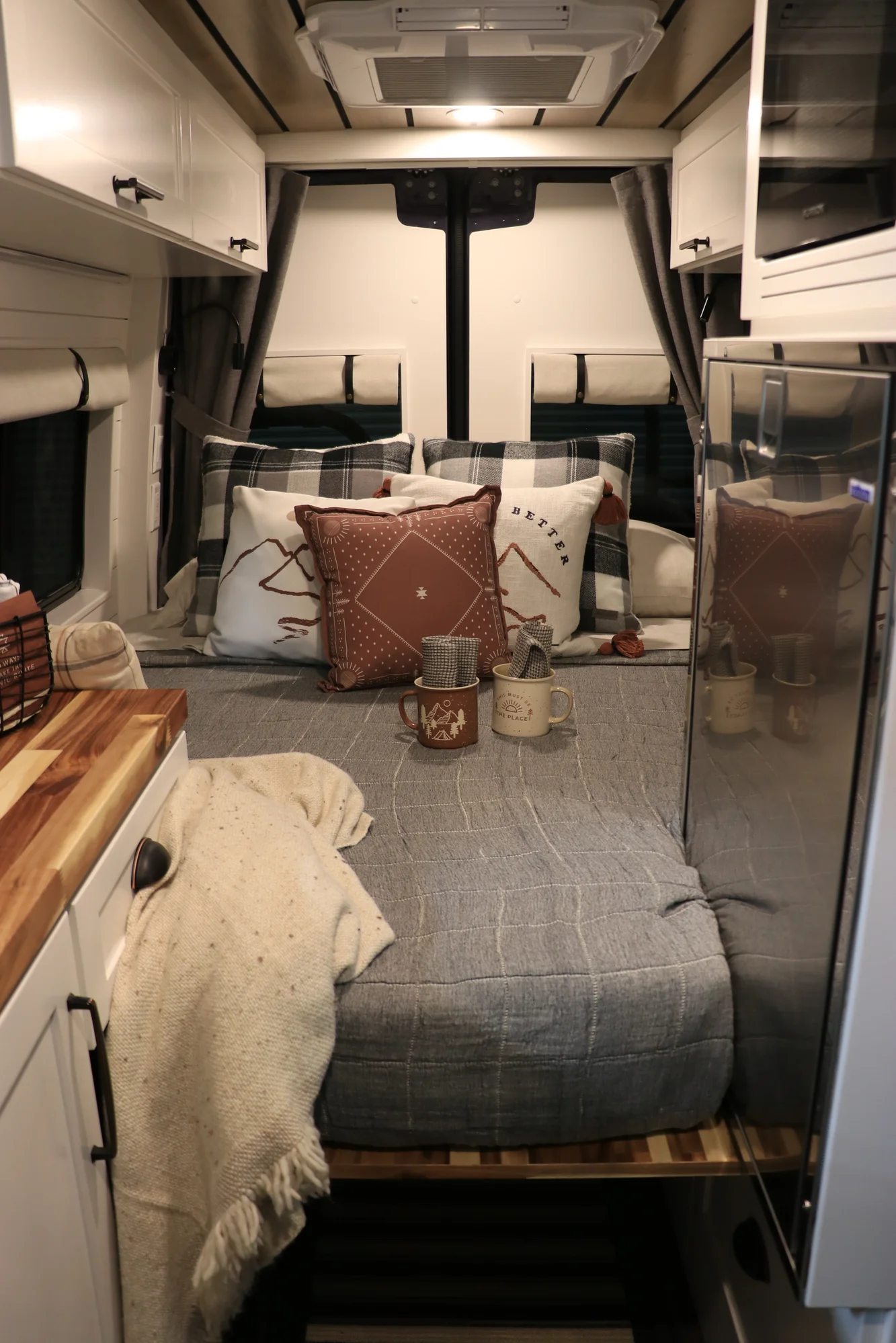 The Drifter 101 custom Mercedes-Benz Sprinter campervan built for Dave by Drifter Vans, with a wood plank ceiling, butcher block countertop, black faucet, and stainless appliances