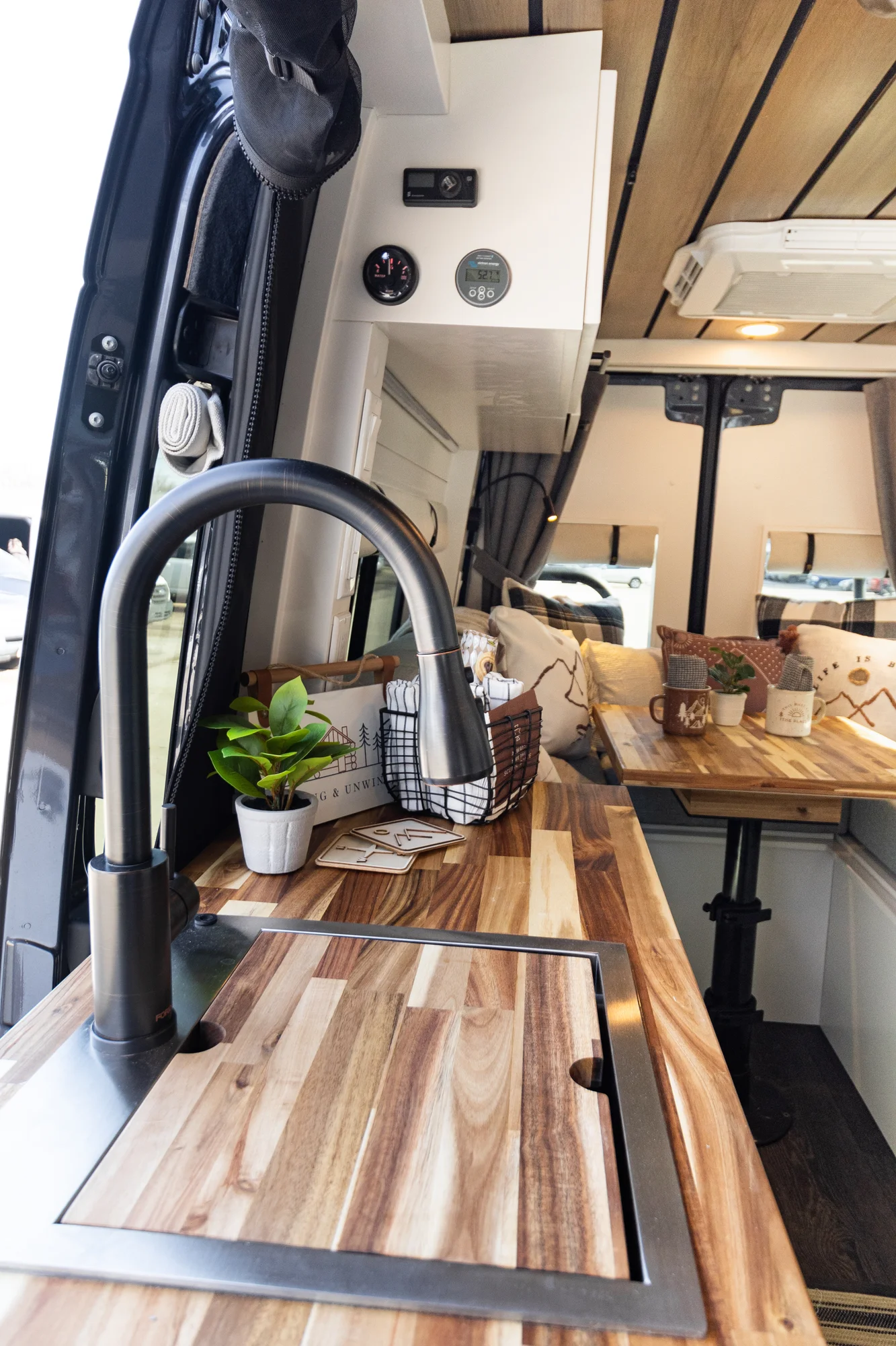 The Drifter 101 custom Mercedes-Benz Sprinter campervan built for Dave by Drifter Vans, with a wood plank ceiling, butcher block countertop, black faucet, and stainless appliances
