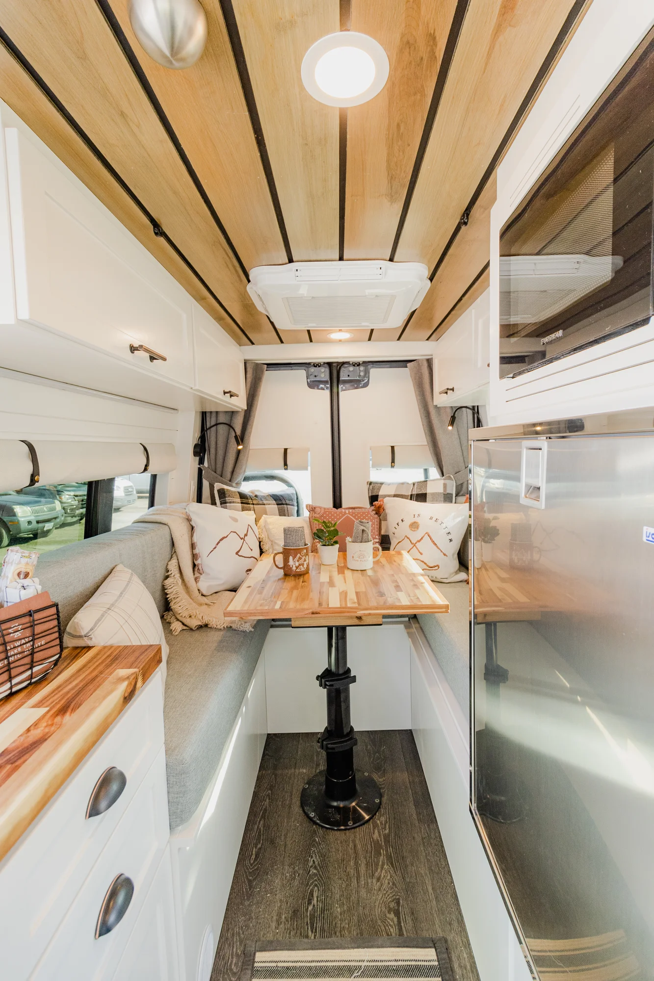 The Drifter 101 custom Mercedes-Benz Sprinter campervan built for Dave by Drifter Vans, with a wood plank ceiling, butcher block countertop, black faucet, and stainless appliances
