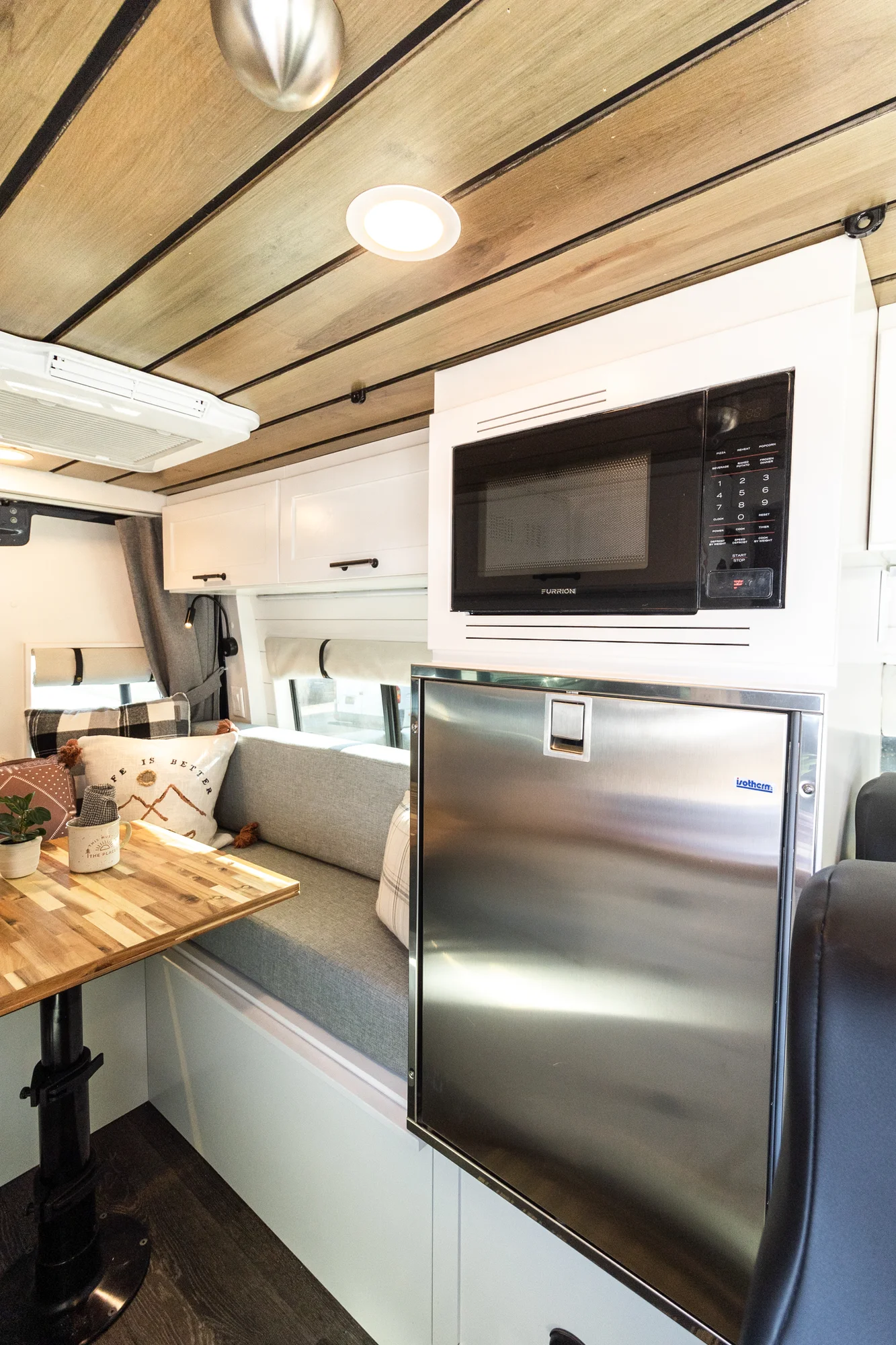 The Drifter 101 custom Mercedes-Benz Sprinter campervan built for Dave by Drifter Vans, with a wood plank ceiling, butcher block countertop, black faucet, and stainless appliances