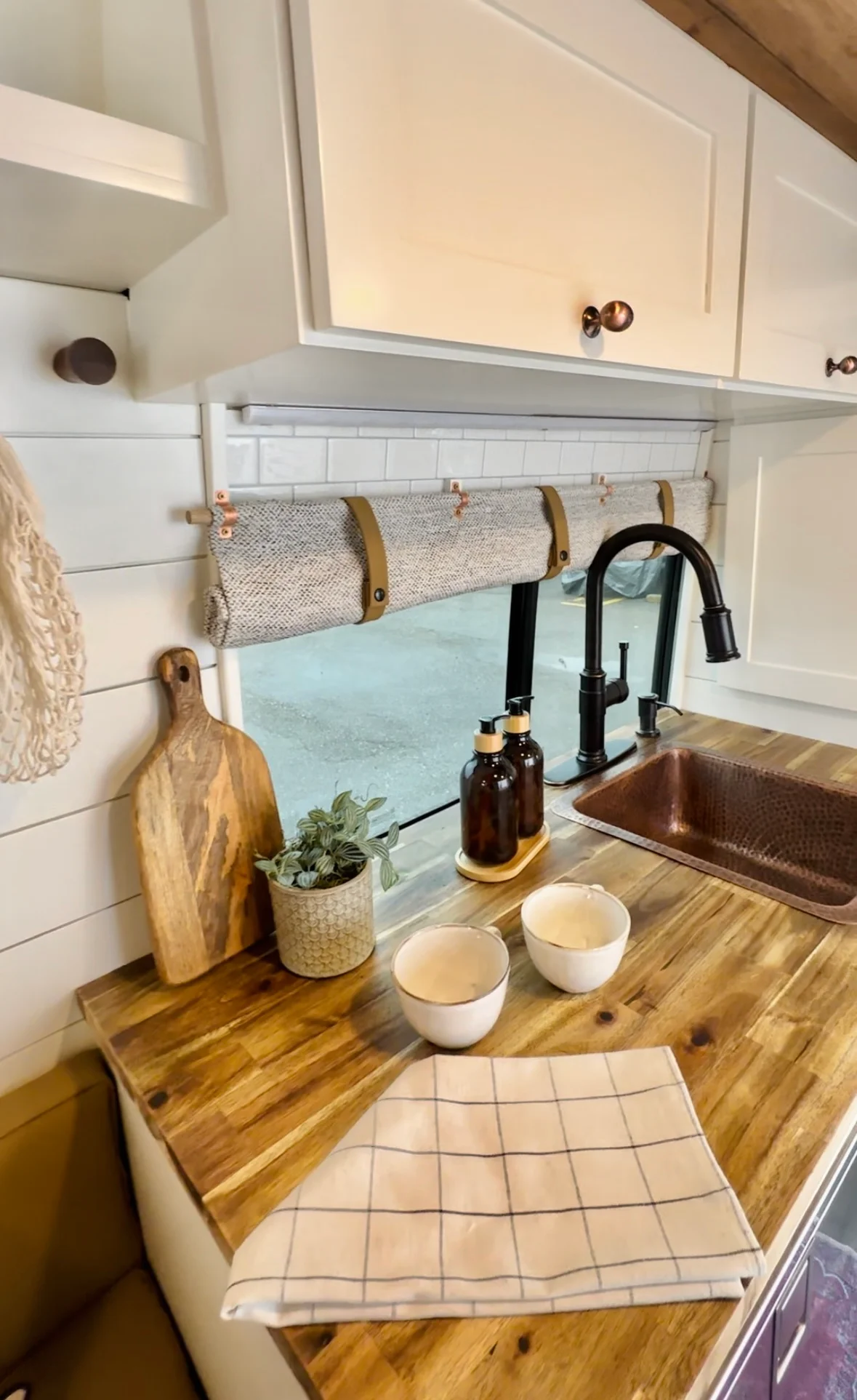 The Drifter 101 custom Ford Transit campervan built for Valerie by Drifter Vans, with a rose boho interior, copper sink, earthy wood tones, and a built-in dog crate