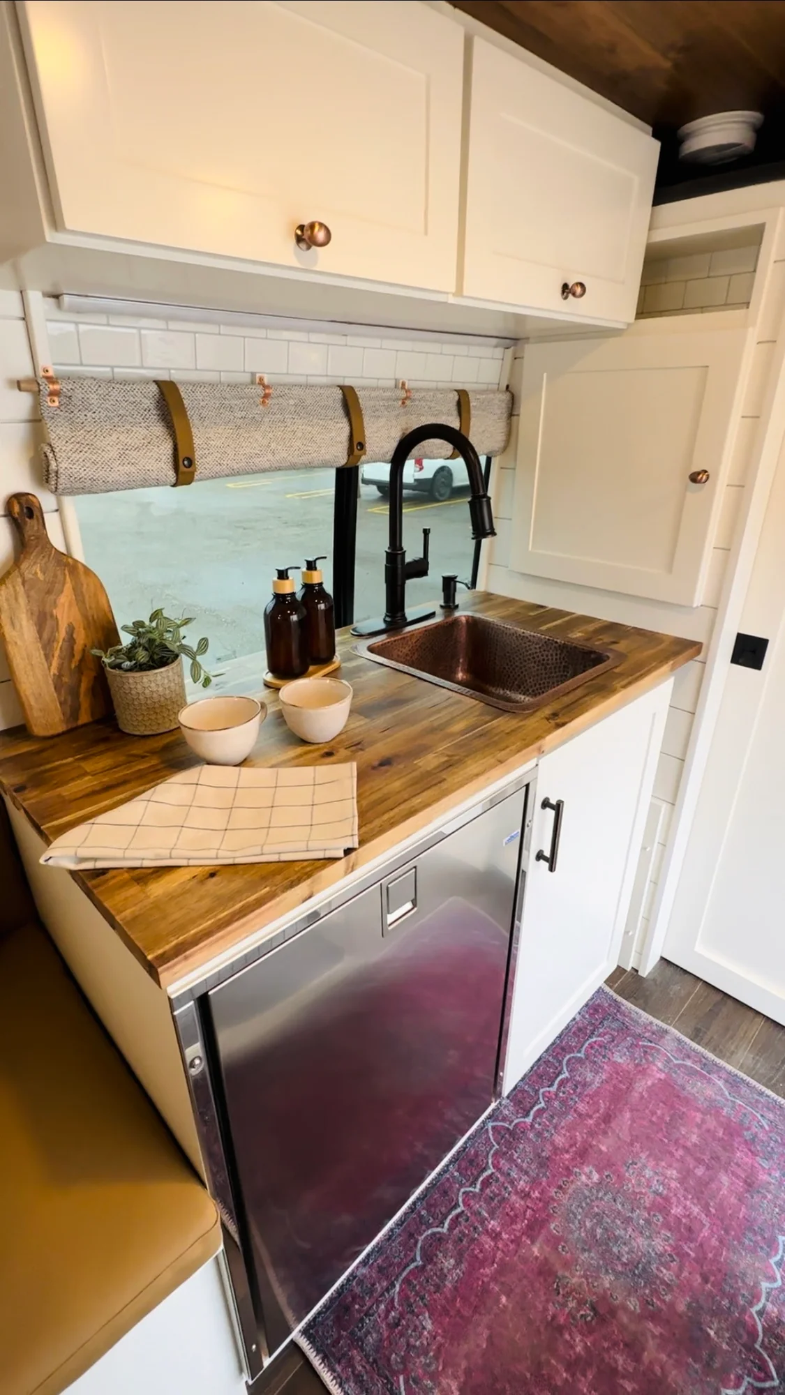 The Drifter 101 custom Ford Transit campervan built for Valerie by Drifter Vans, with a rose boho interior, copper sink, earthy wood tones, and a built-in dog crate