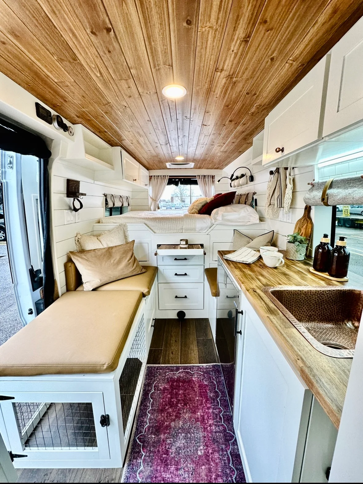 The Drifter 101 custom Ford Transit campervan built for Valerie by Drifter Vans, with a rose boho interior, copper sink, earthy wood tones, and a built-in dog crate