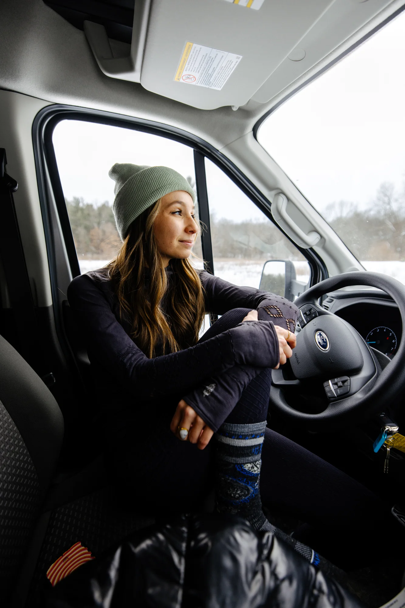The Drifter 101 custom Ford Transit campervan built for Adrianne by Drifter Vans, Nomadik layout with knotty pine accents, soft green cabinetry, and a gold rain shower