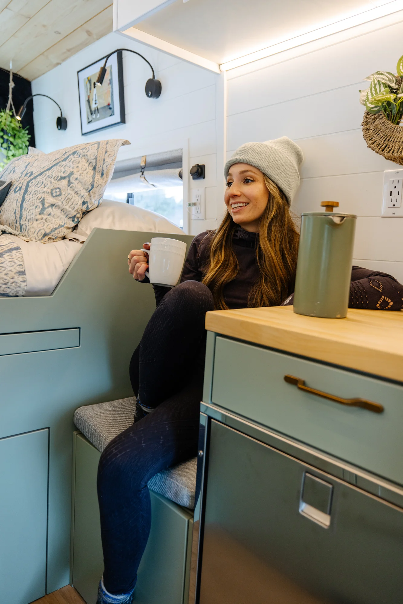 The Drifter 101 custom Ford Transit campervan built for Adrianne by Drifter Vans, Nomadik layout with knotty pine accents, soft green cabinetry, and a gold rain shower