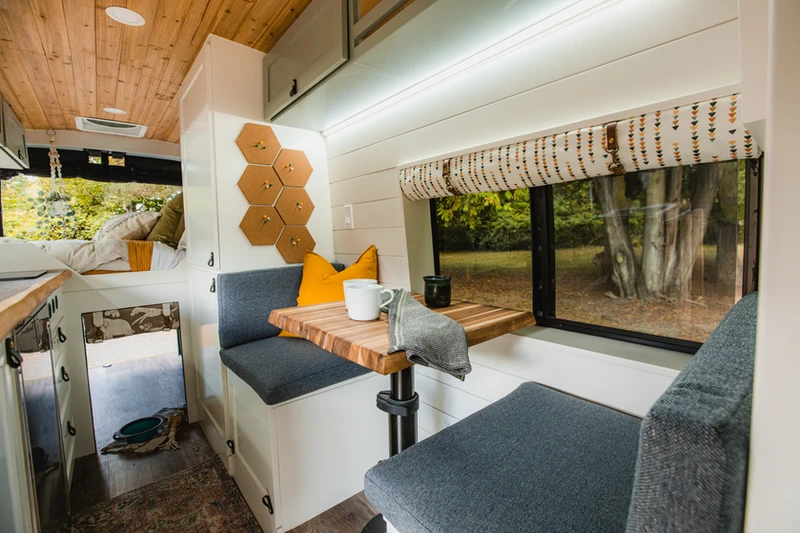 Travel nurse van life – cozy interior of Tess’s custom Drifter Vans Class B coach with bed, cabinets, and warm lighting