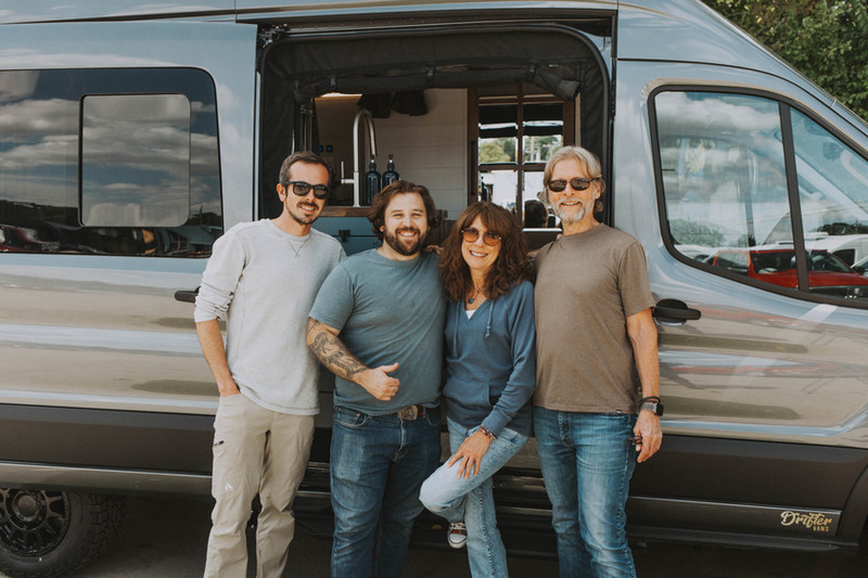 Paul Domish with clients in front of their newly completed custom camper van at Drifter Vans HQ.