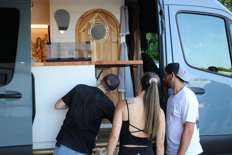drifter vans employee showing new client how to adjust something in their new van