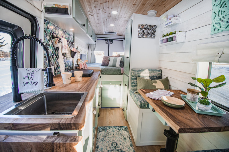 Interior of Julie’s Drifter Van, featuring custom-built cabinetry, cozy seating, and high-end campervan design.