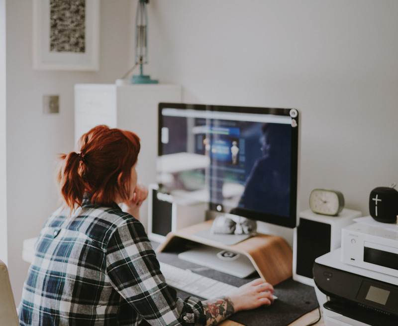 Photo of a woman preparing to start work at her desk, with a focused and organized workspace.