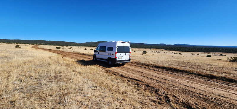 Susan’s van driving down a quiet, remote road surrounded by open landscape, capturing the spirit of solo travel and freedom.
