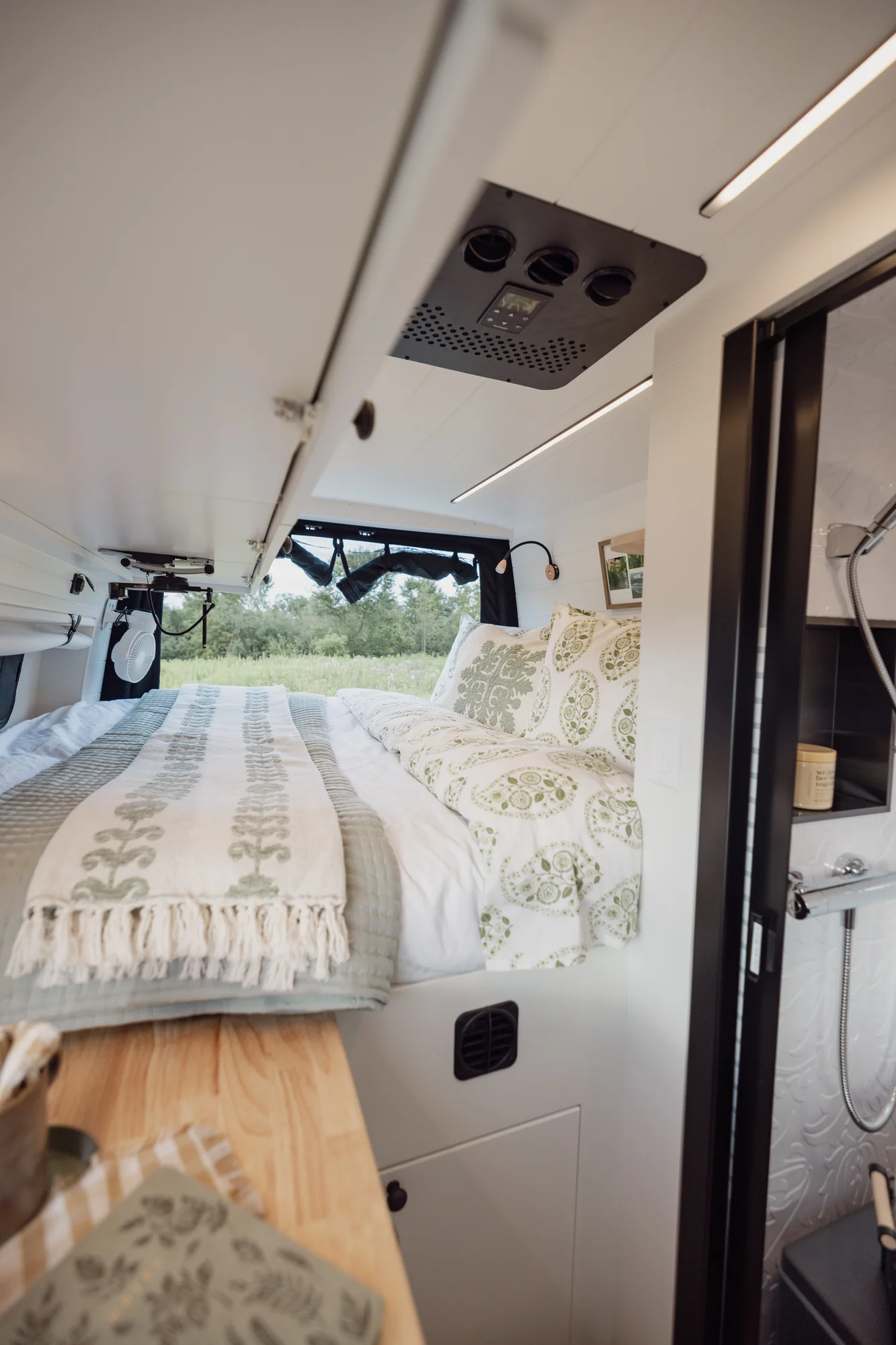 The Drifter 101 custom Mercedes-Benz Sprinter campervan built for Tanya by Drifter Vans, rustic interior with light blue cabinetry, butcher block countertop, and oil-rubbed bronze fixtures