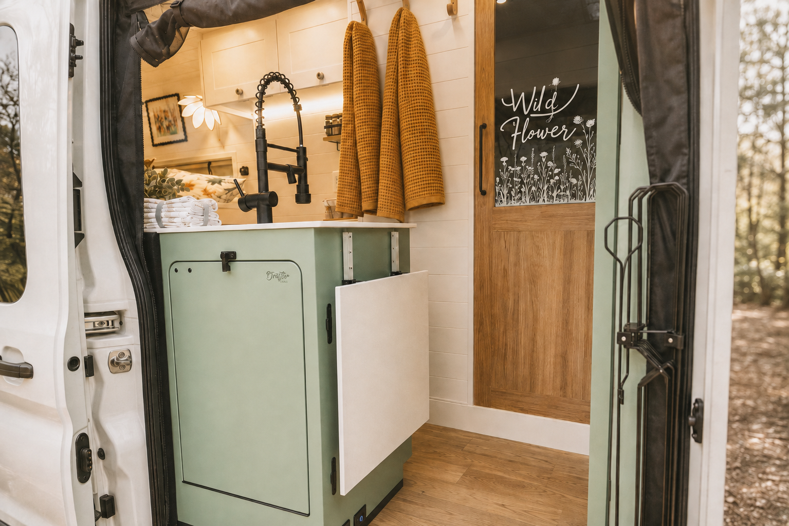 The Drifter 101 custom Ford Transit campervan built for Michelle by Drifter Vans, Nomadik layout with Lehigh Green cabinetry, Alabaster shiplap, a custom white oak shower door, and a stage 4 lift