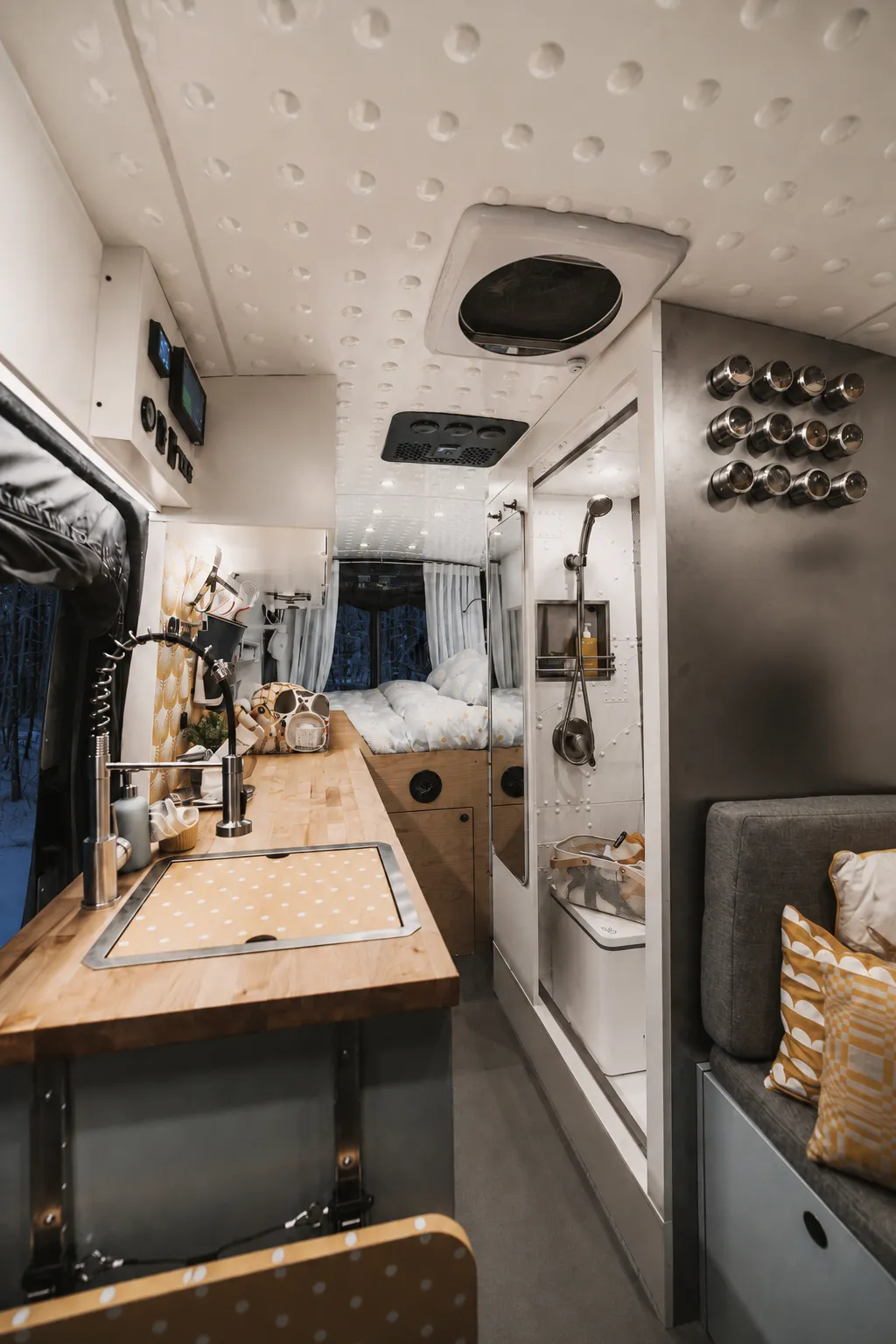 The Drifter 101 Ford Transit campervan built for Edward and Caroline by Drifter Vans: full interior view with butcher block galley, riveted aviation-style ceiling, walk-in wet bath with shower and rear bed