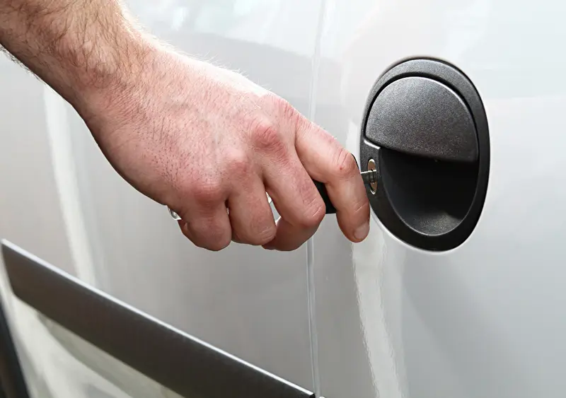 Hand locking a campervan door with a key, van security basics for protecting your vehicle and valuables on the road