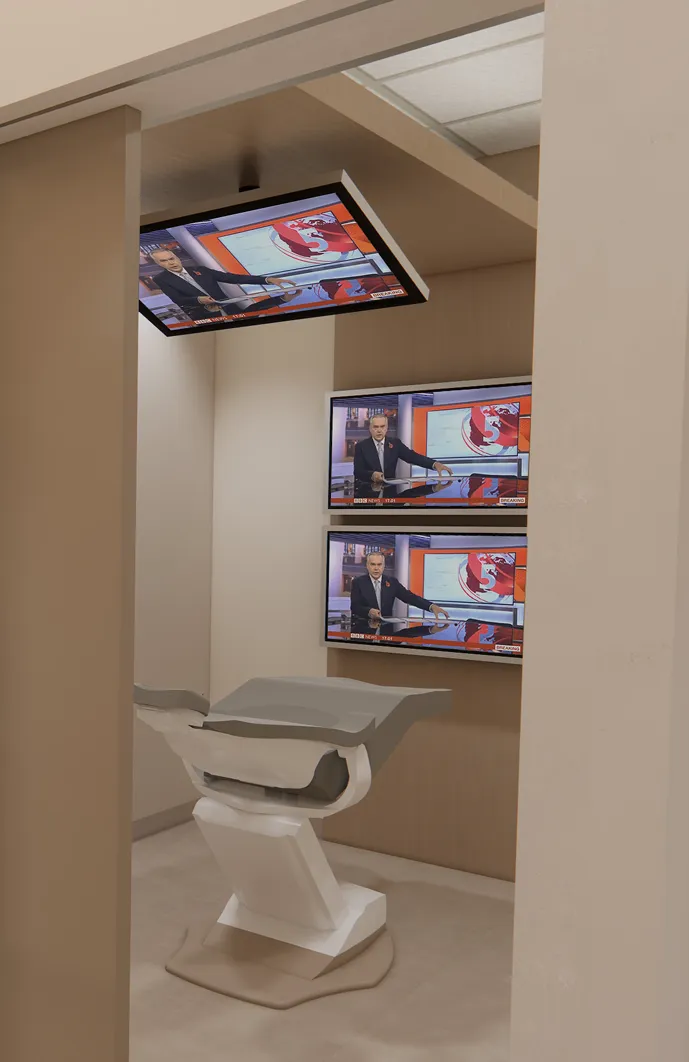 A modern broadcasting studio with large screens showing a news presenter and graphics.