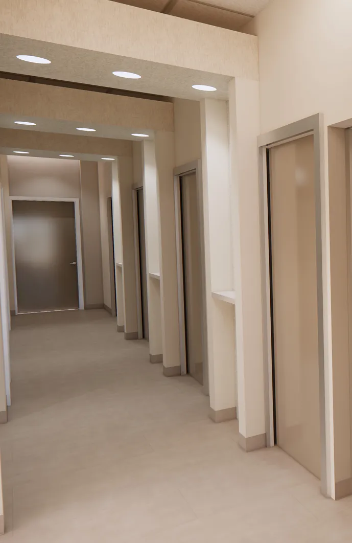 A hallway with multiple closed doors on both sides and ceiling lights overhead.