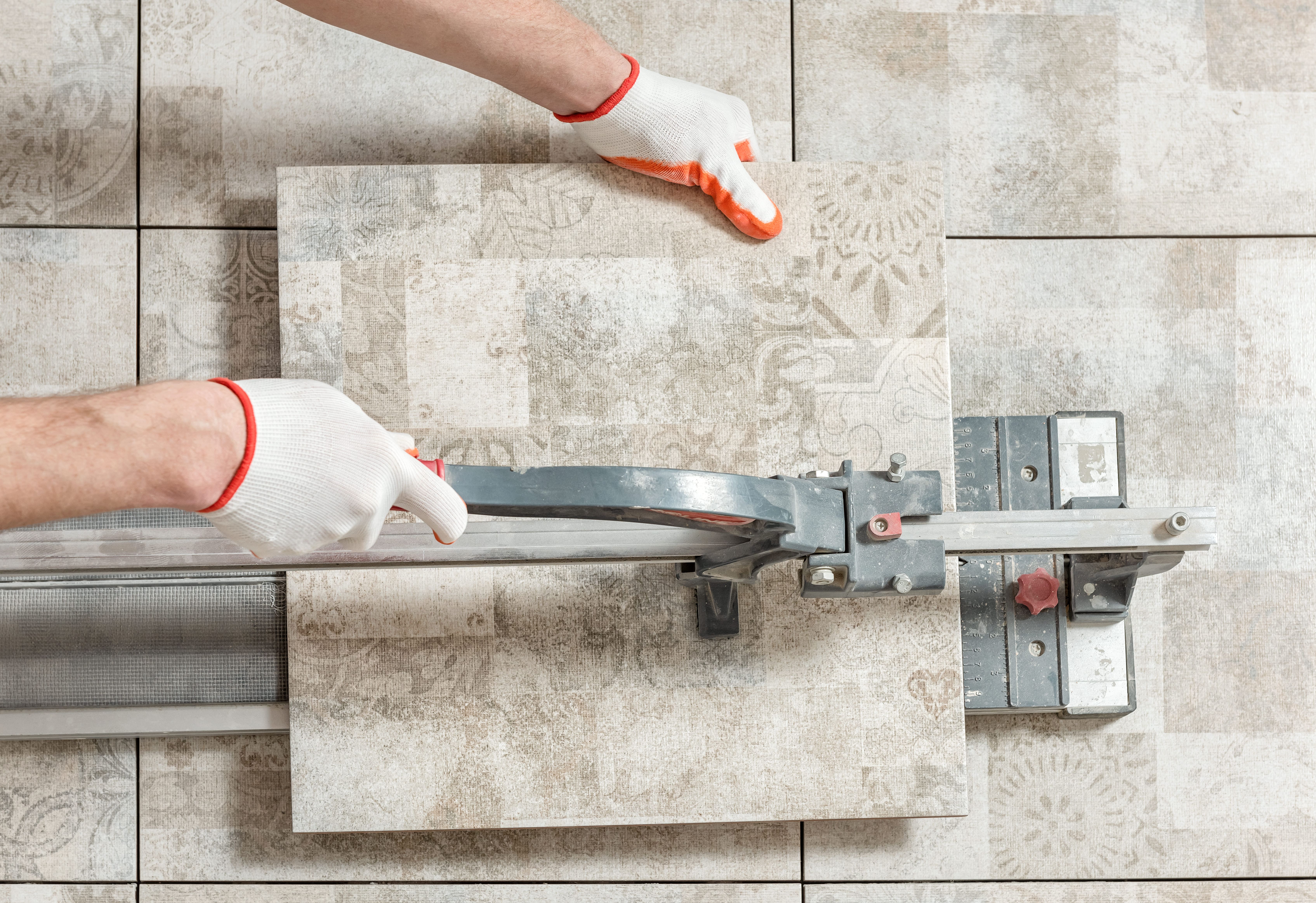 Vloertegel wordt op maat gesneden tijdens een woningrenovatie voor een nauwkeurige plaatsing en hoogwaardige tegelafwerking.