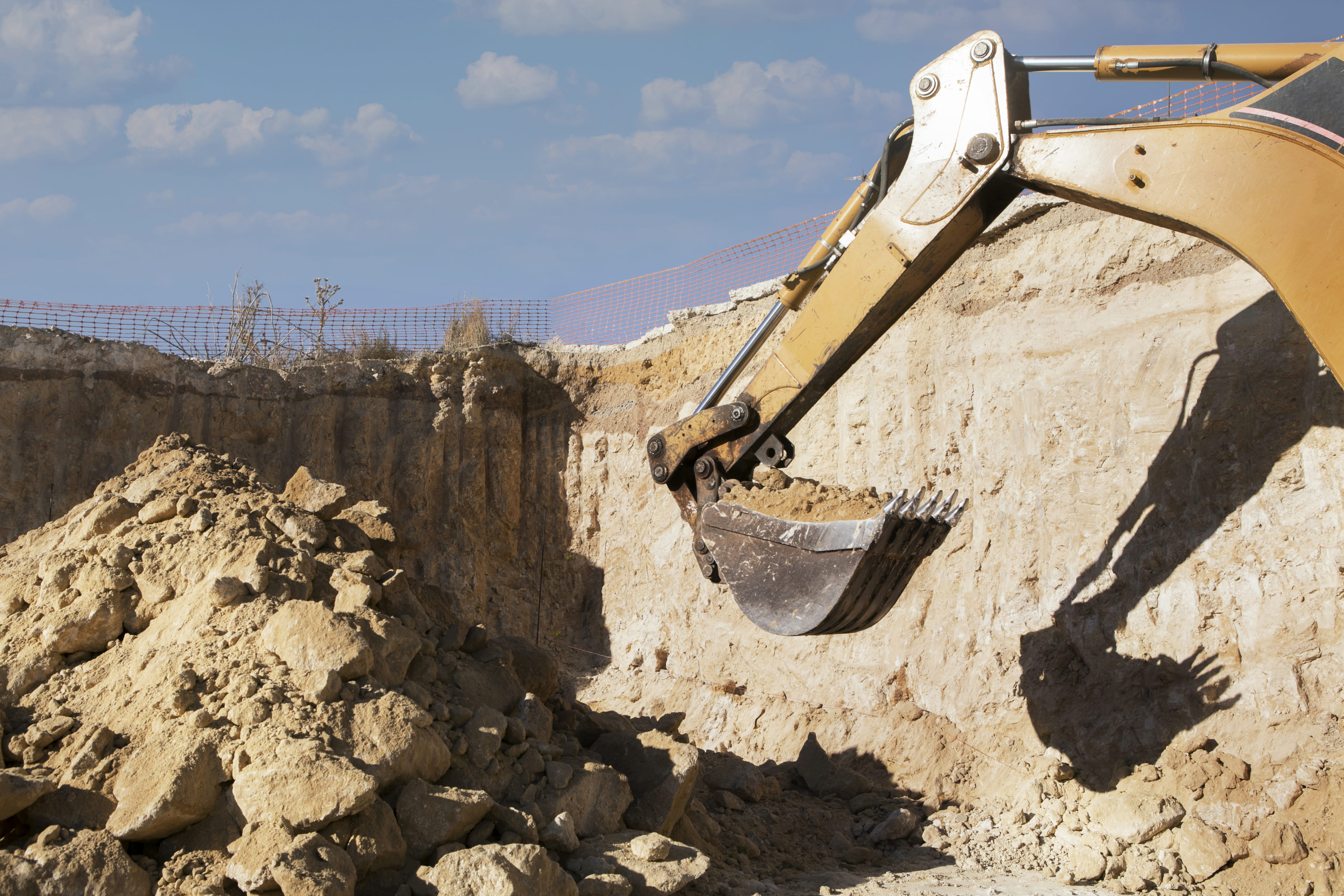 Graafmachine voert grondwerk uit voor de aanleg van een fundering bij een nieuwbouwproject met uitgegraven bouwput.
