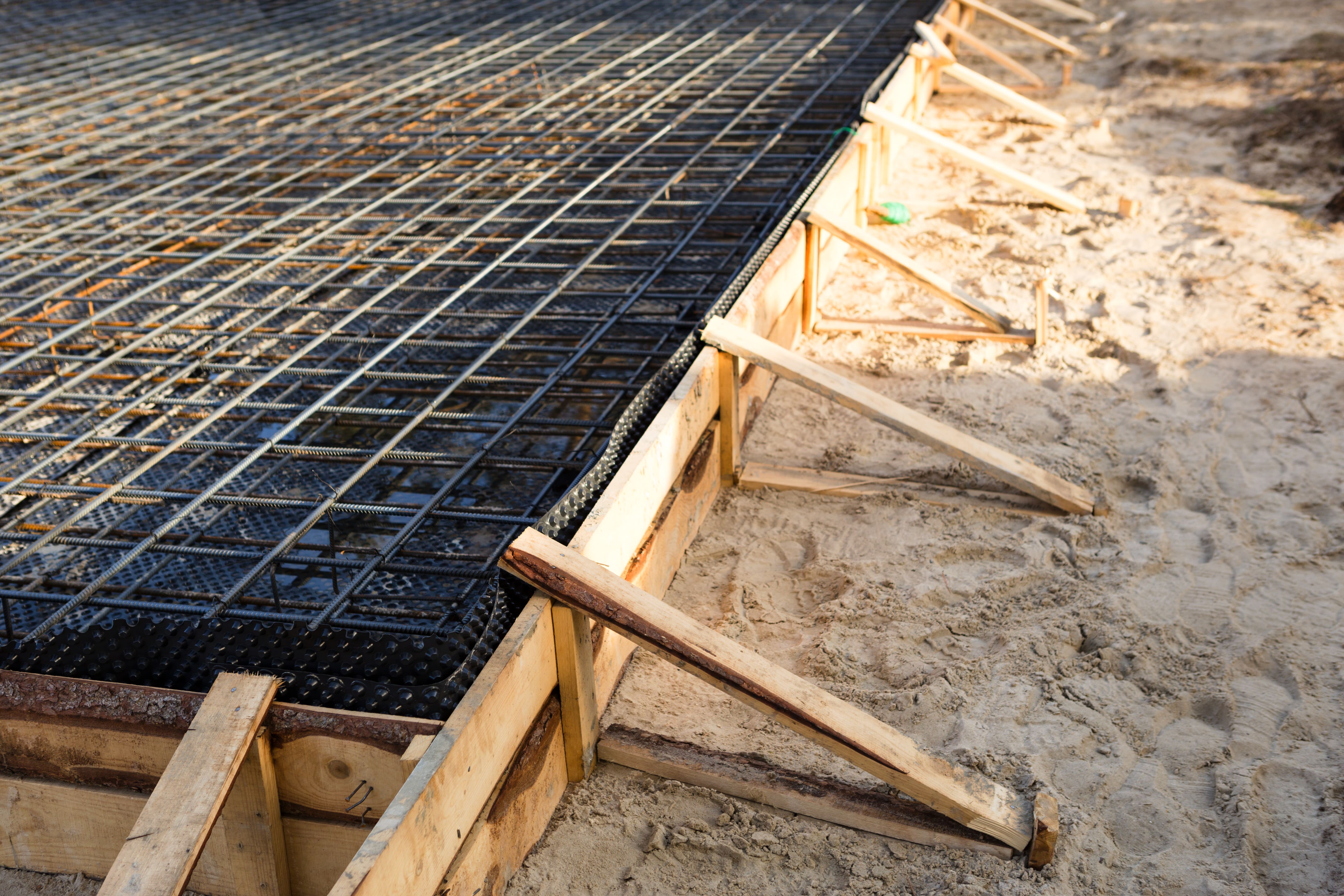 Houten bekisting en bewapende fundering voorbereid voor nieuwbouw als basis voor professioneel timmerwerk en houtconstructies.