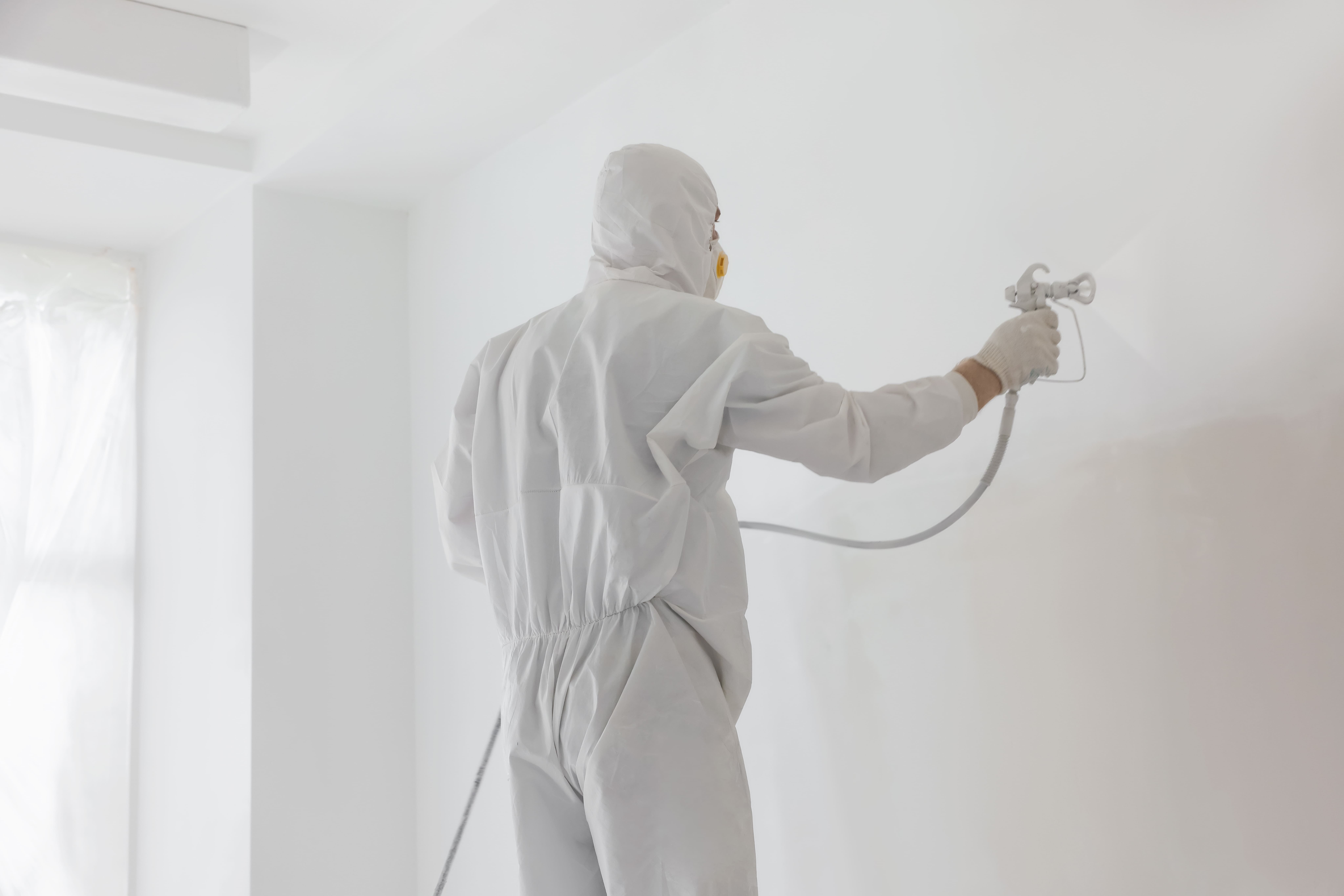 Professioneel spuitwerk voor een egale wandafwerking in een woning tijdens schilder- en renovatiewerkzaamheden.