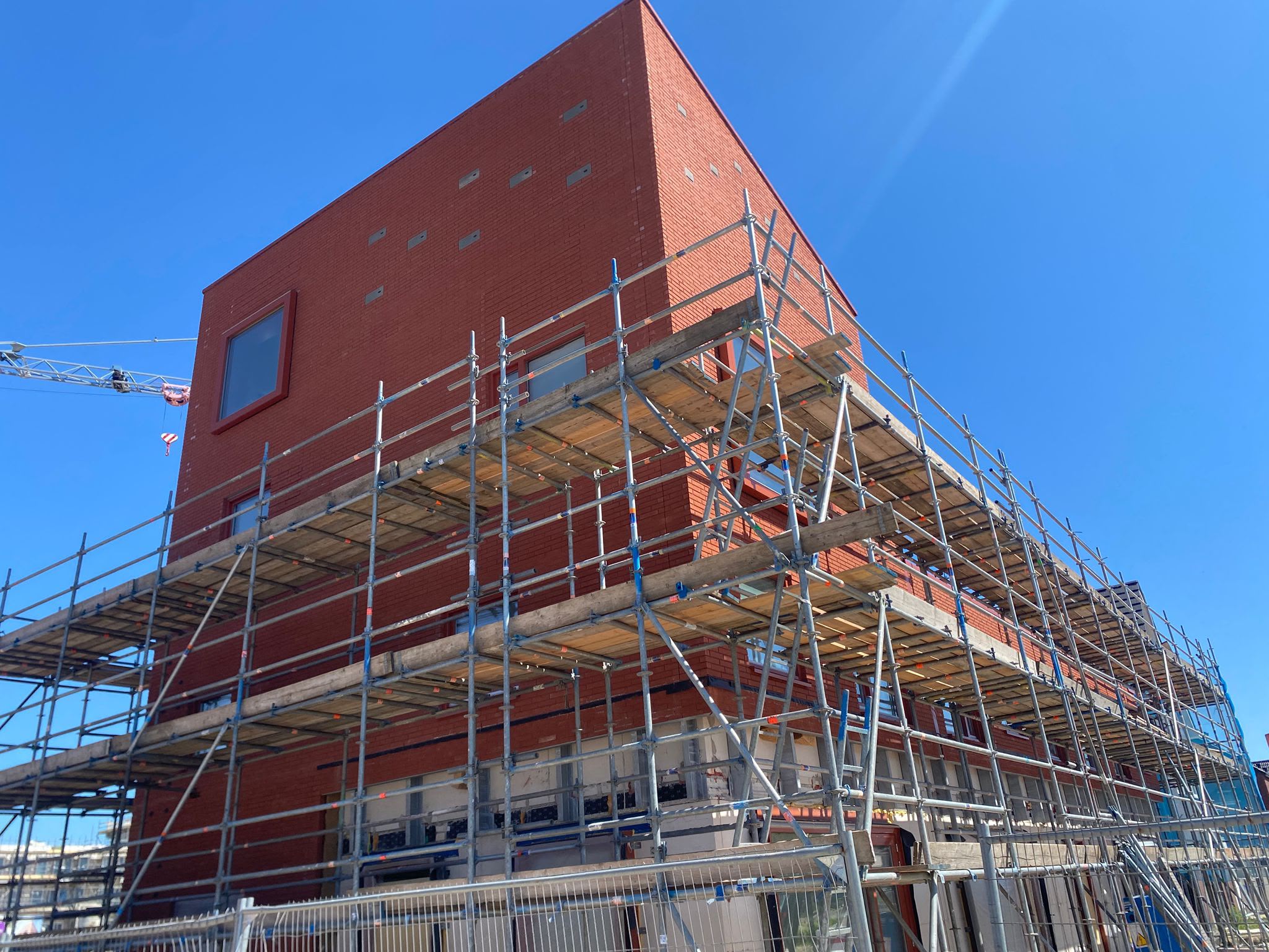 Steigerbouw rondom nieuwbouwproject met bakstenen gevel