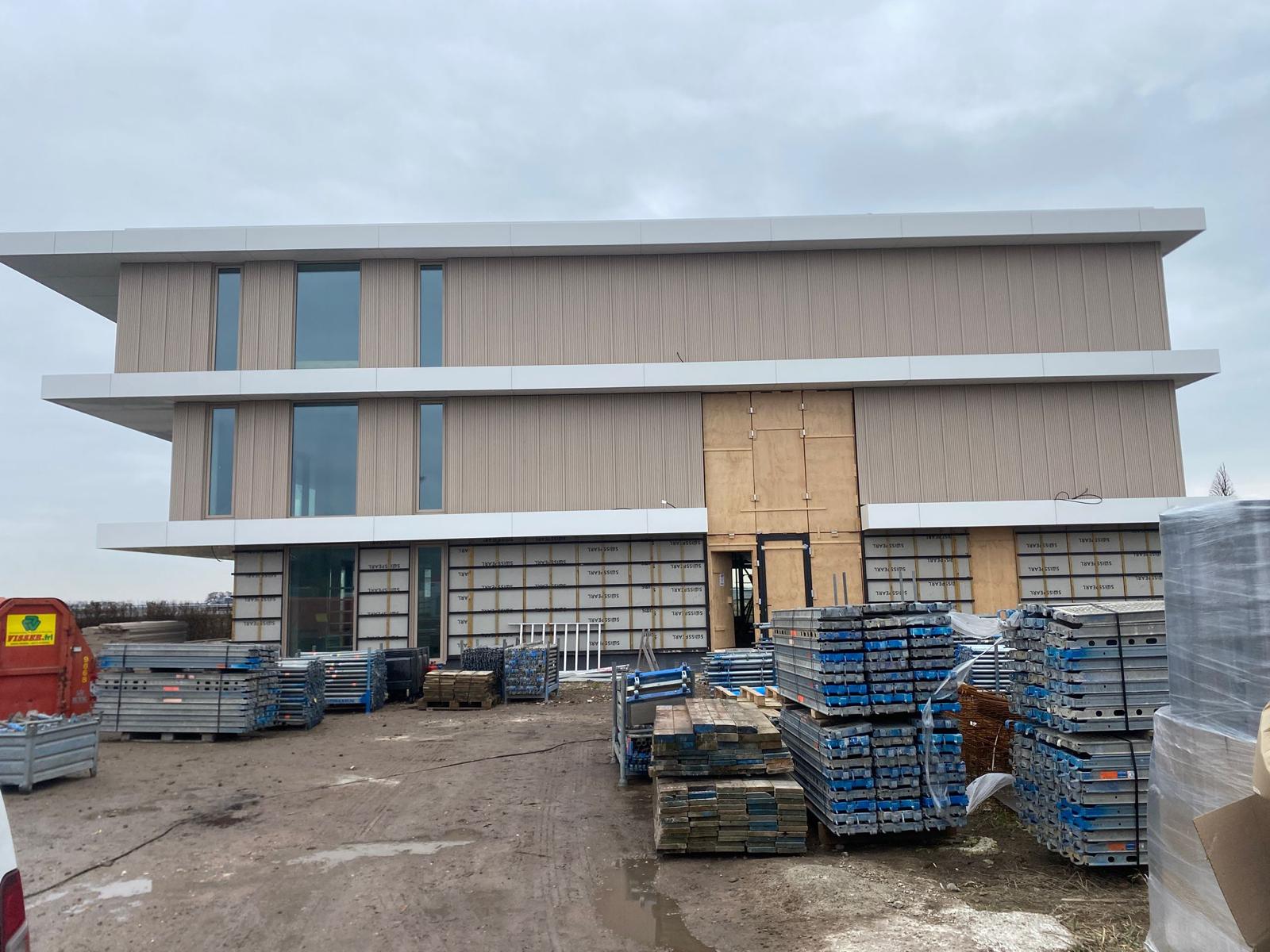 Afgeleverd steigerwerk rondom modern bedrijfspand in aanbouw