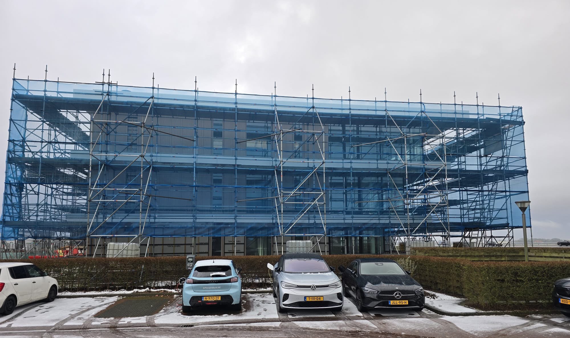 Steigerconstructie rondom commercieel bedrijfspand tijdens renovatie