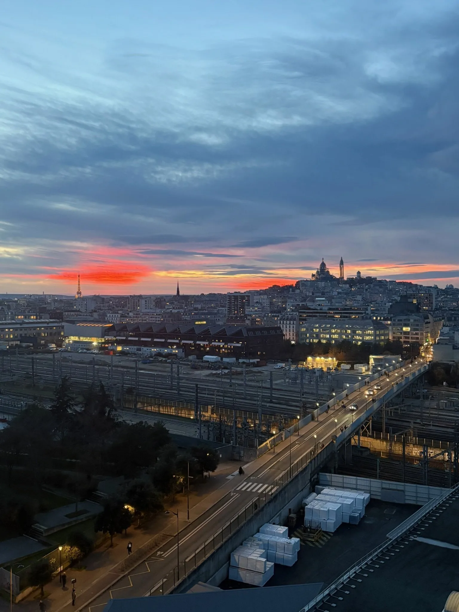 Coucher de soleil sur Paris avec le Sacré-Cœur en ligne d'horizon, vue depuis les toits