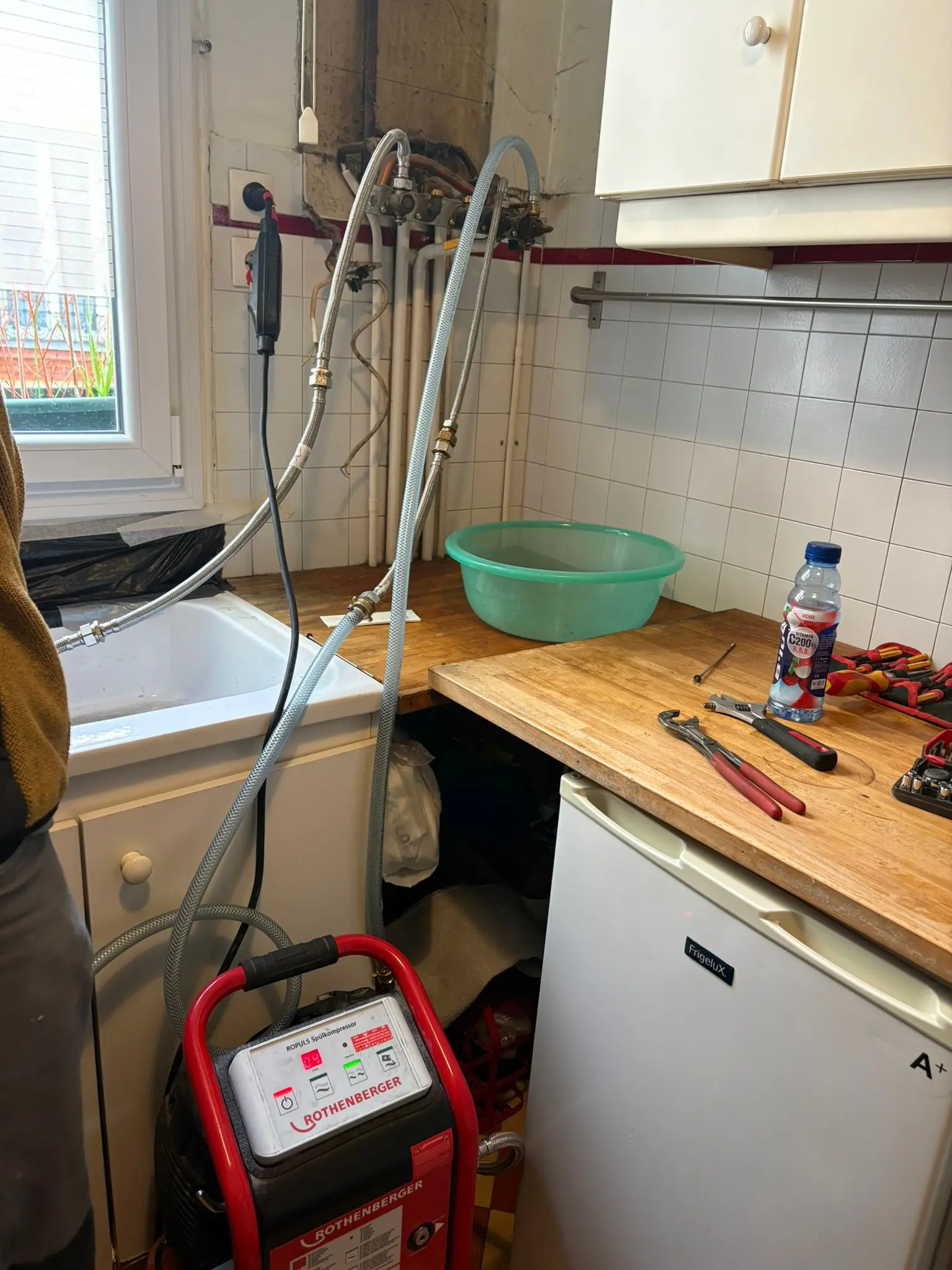 Pompe de désembouage Rothenberger raccordée à la nourrice de chauffage d'un appartement