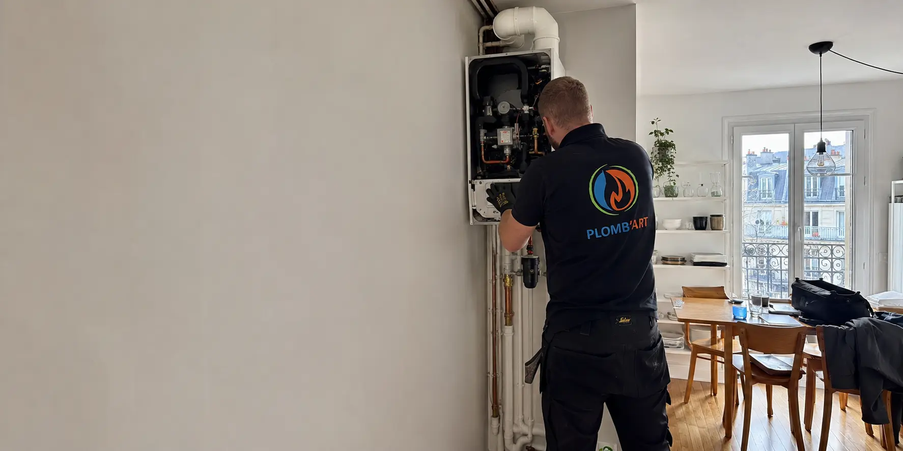 Entretien d'une chaudière gaz capot ouvert, conduit d'évacuation et raccordements bien visibles