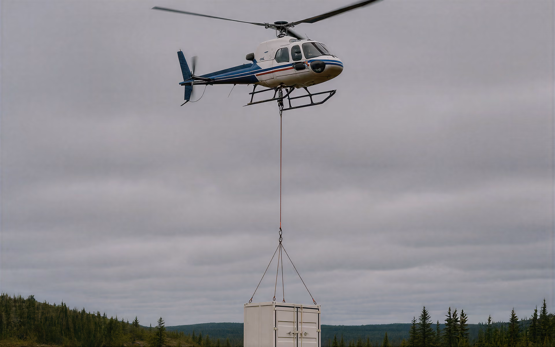 Helicopter lifting a heli-portable drill component to a remote drill site
